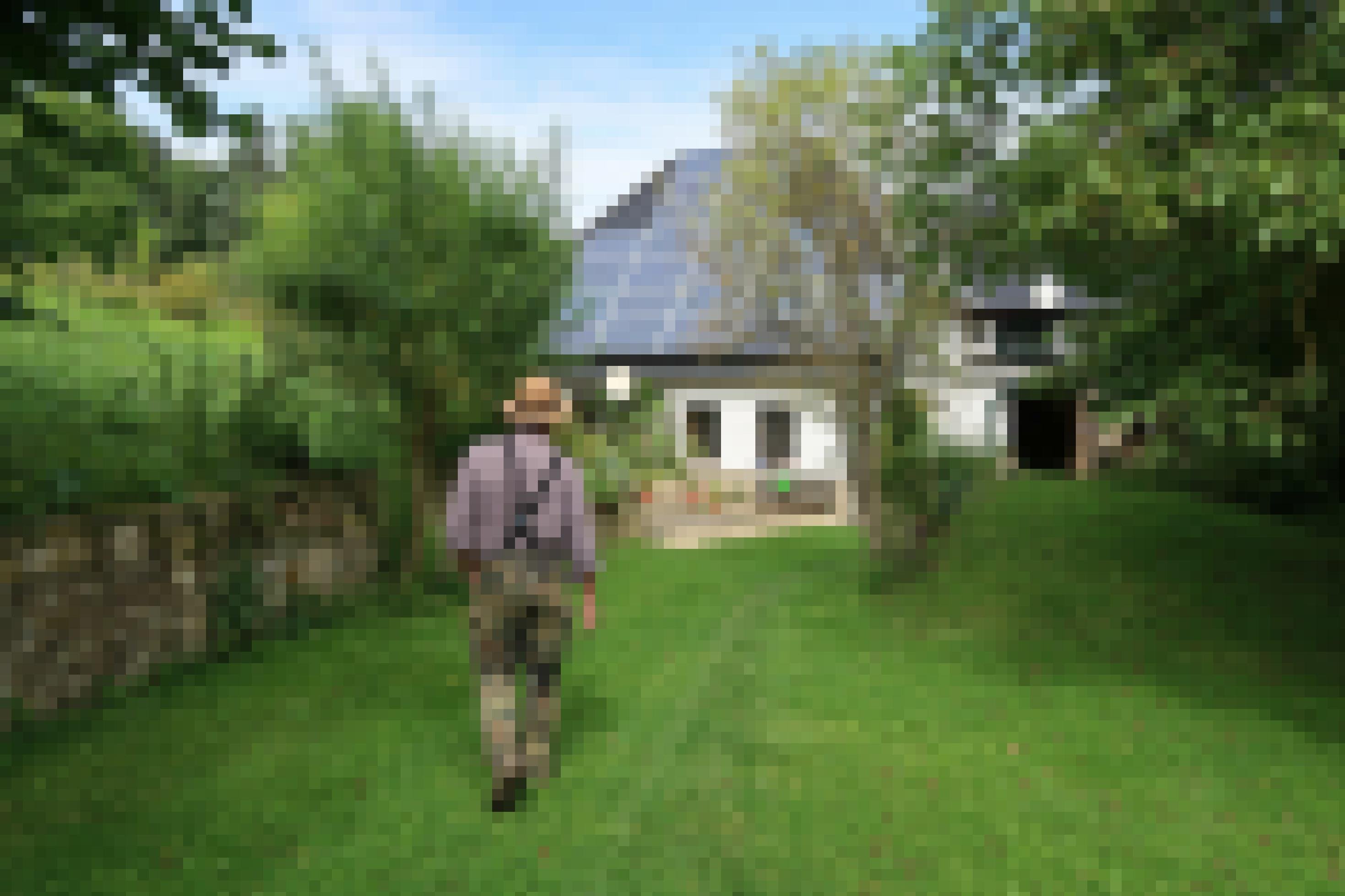Ein Mann läuft durch seinen Garten, im Hintergrund ein Haus mit Solardach.