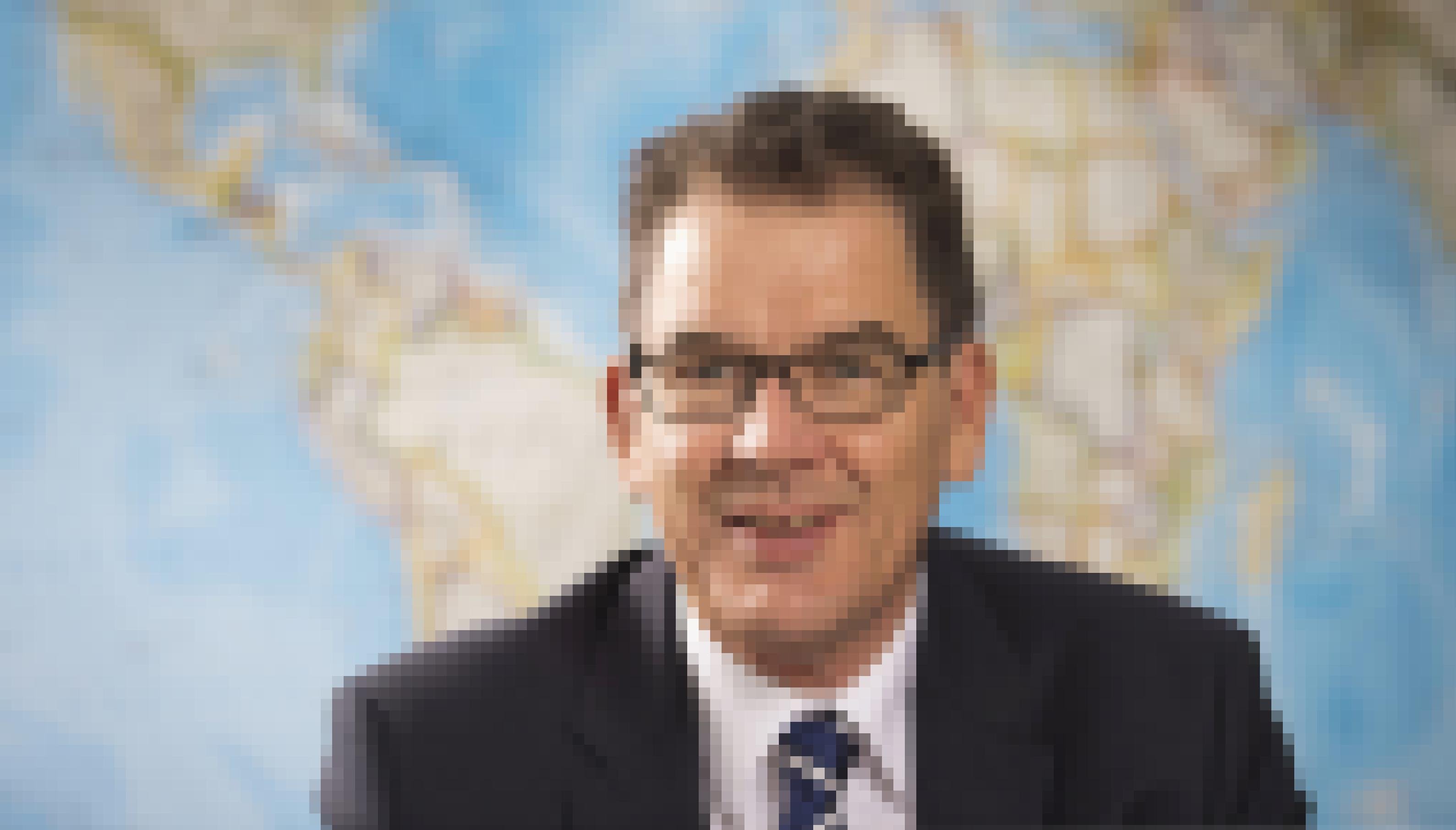 Das Foto zeigt Minister Müller im Portrait vor einer Weltkarte.