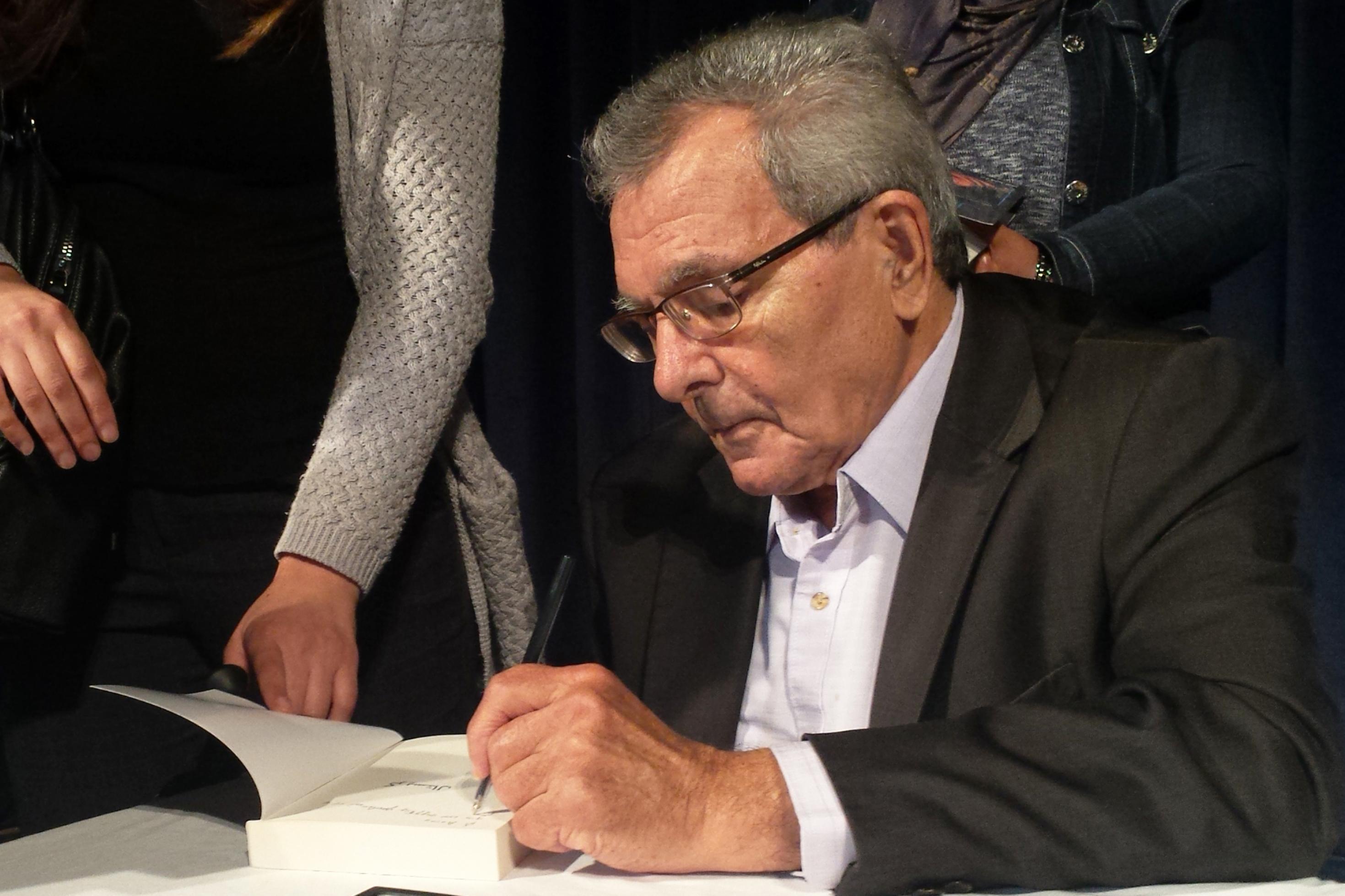 Der tunesische Schriftsteller Gilbert Naccache signiert ein Buch.