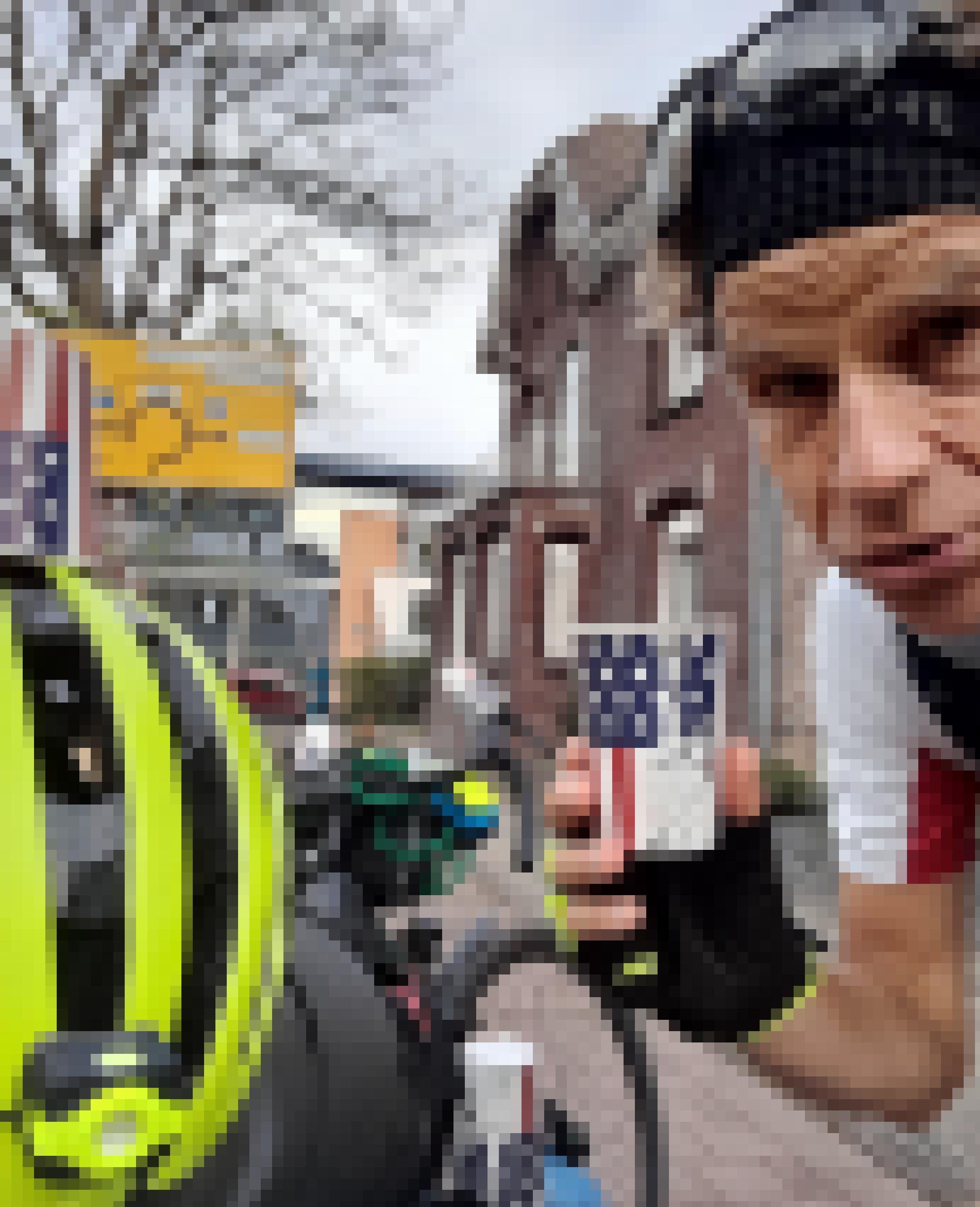 Am Ende einer niederländisch-deutschen Straße hält der Reporter einen Becher mit den Insignien der USA in der Hand, wie er ihn zu mehreren auch auf Radhelm und Rennrad drapiert hat.