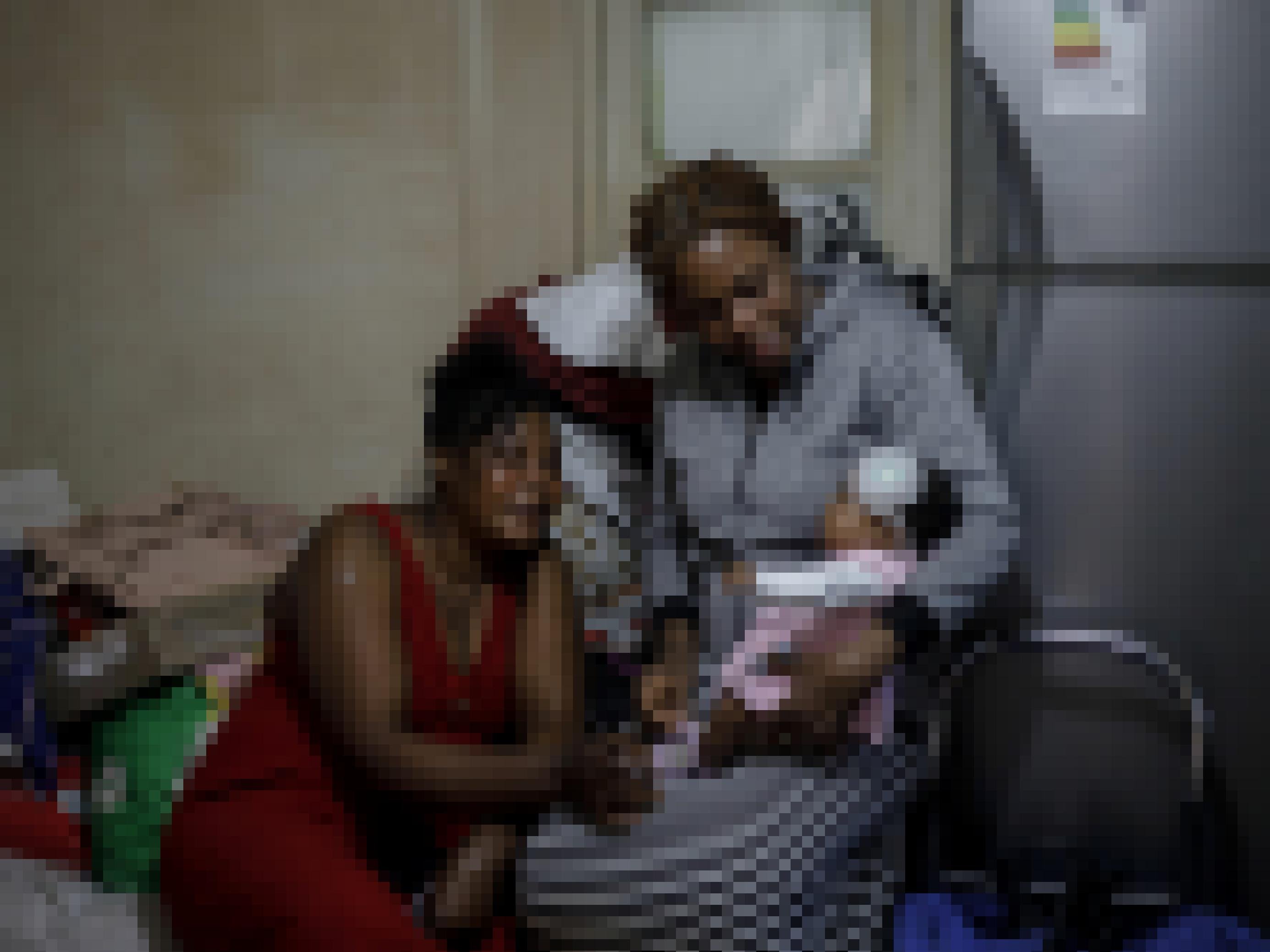 Zwei Frauen aus Haiti schauen einem neugeborenen Baby in die Augen.