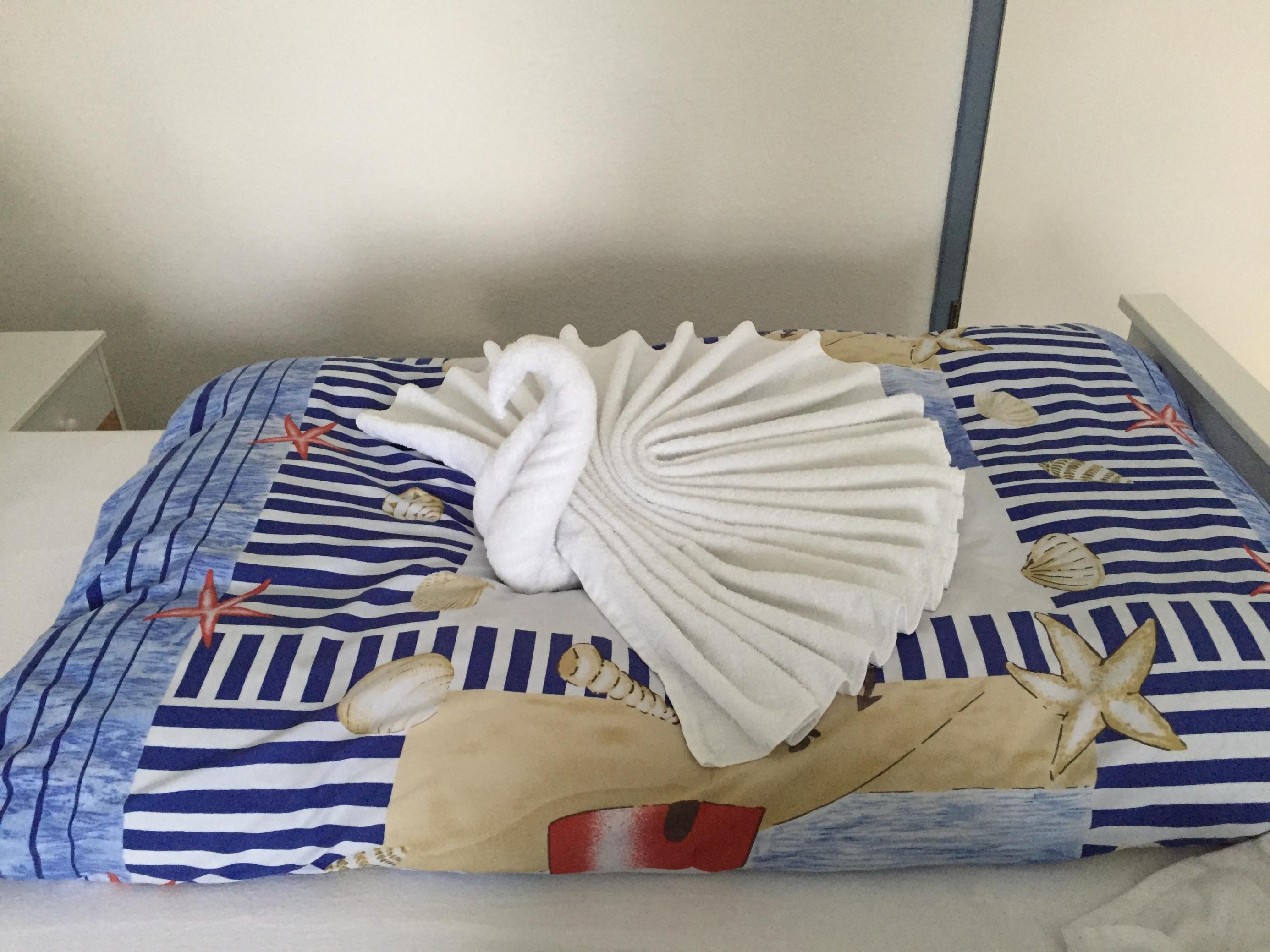 Ein aus Frottee-Handtüchern geformter Schwan liegt auf dem Bett in einer Pension in Horumersiel am Wattenmeer-Nationalpark.