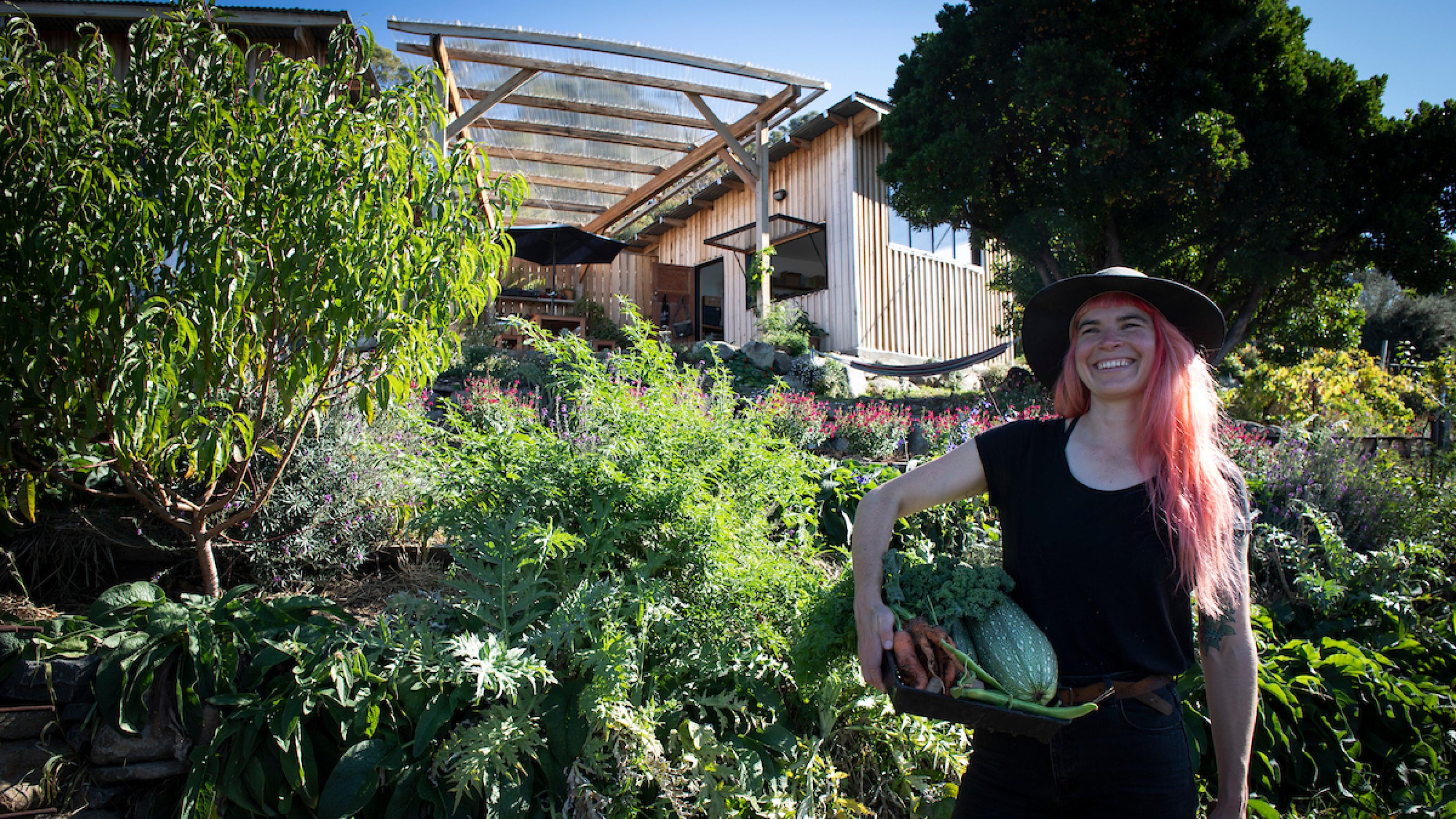 Hannah Moloney steht mit Gemüse im Garten ihres Hauses in der tasmanischen Hauptstadt Hobart. Ihr Weg das Klima zu schützen ist annstecken.