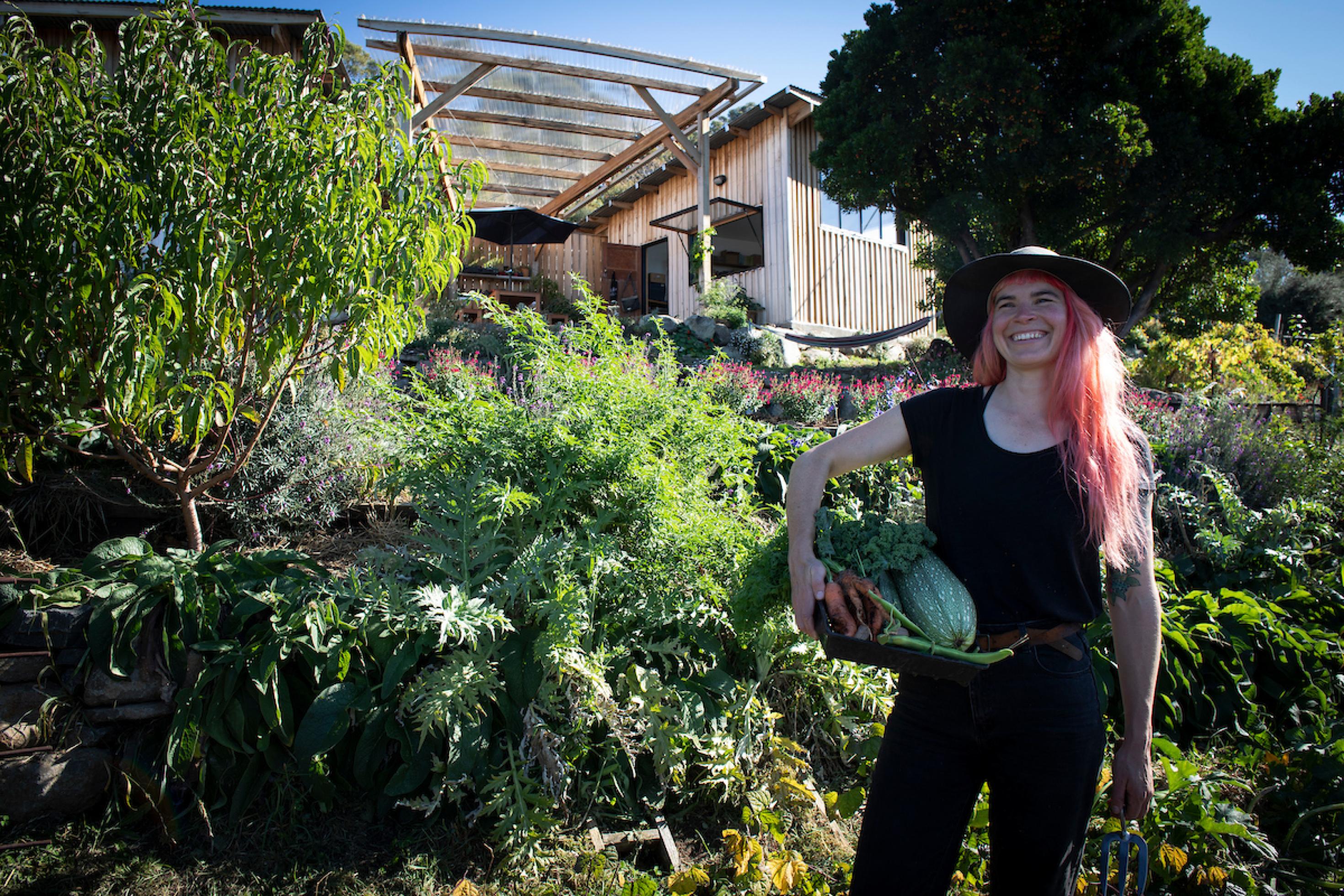 Hannah Moloney steht mit Gemüse im Garten ihres Hauses in der tasmanischen Hauptstadt Hobart. Ihr Weg das Klima zu schützen ist annstecken.