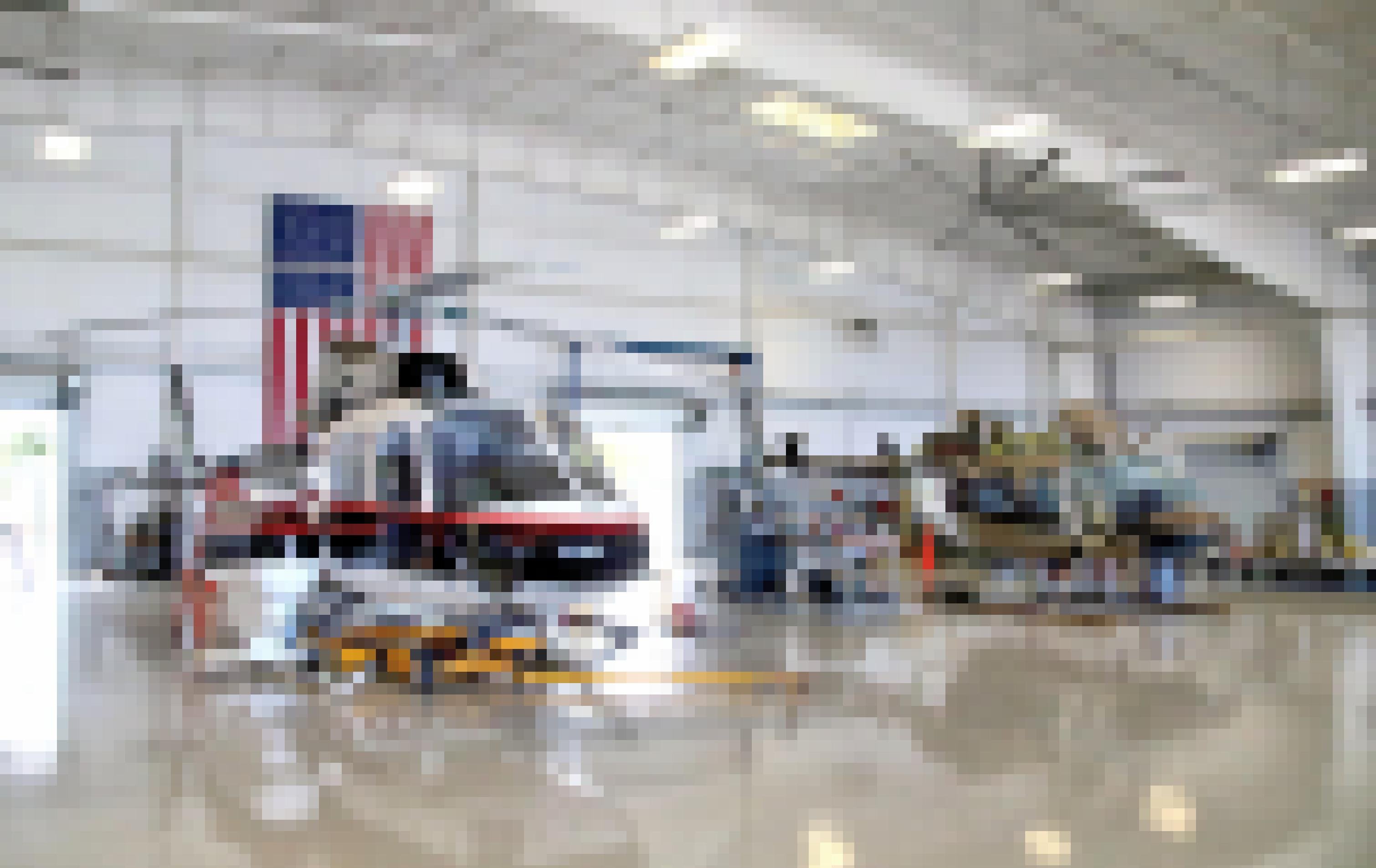 Zwei Helikopter stehen in einem Hangar, im Hintergrund hängt die USA-Fahne