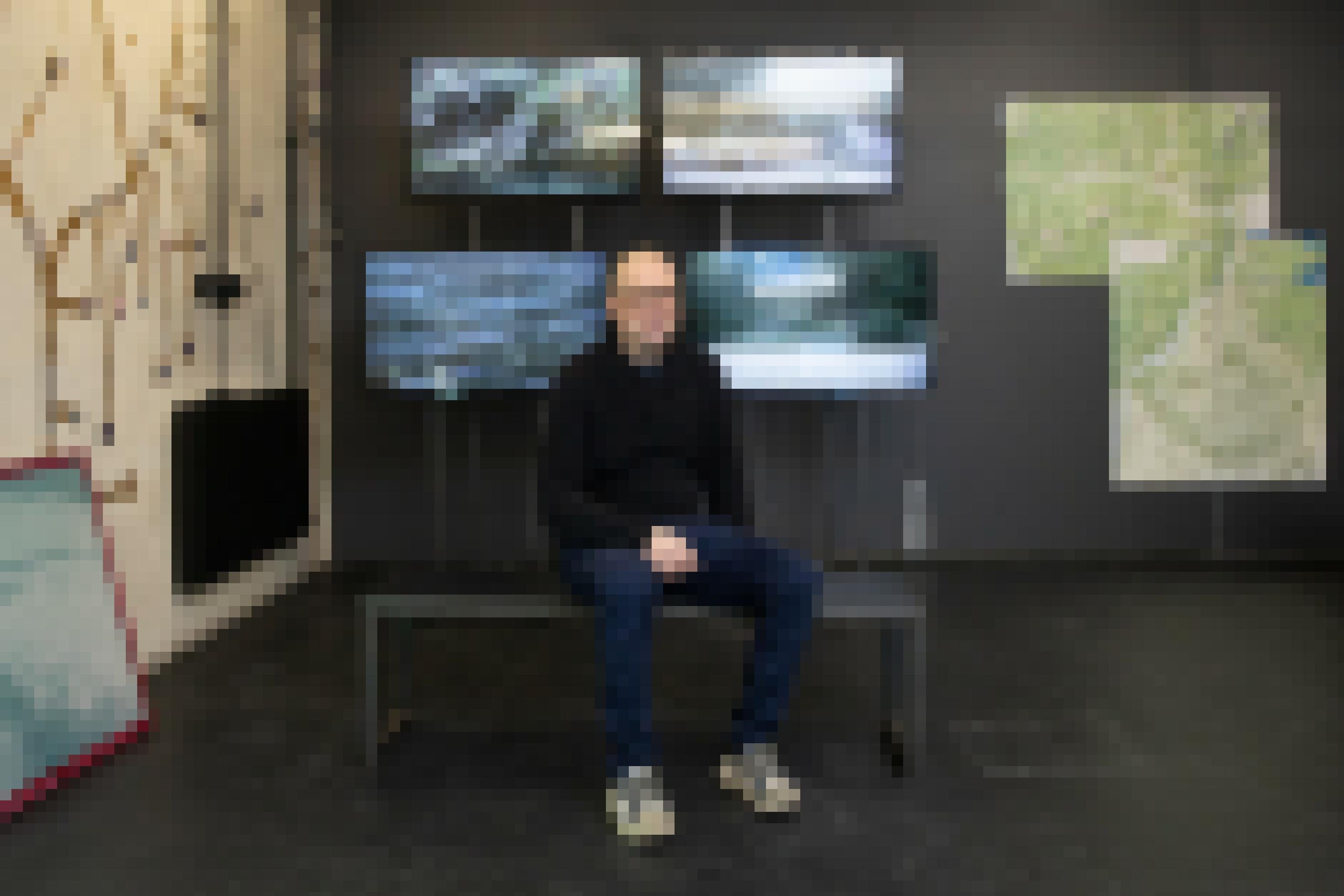 Der Fotograf Herwig Turk sitzt vor Videobildschirmen in seiner Ausstellung