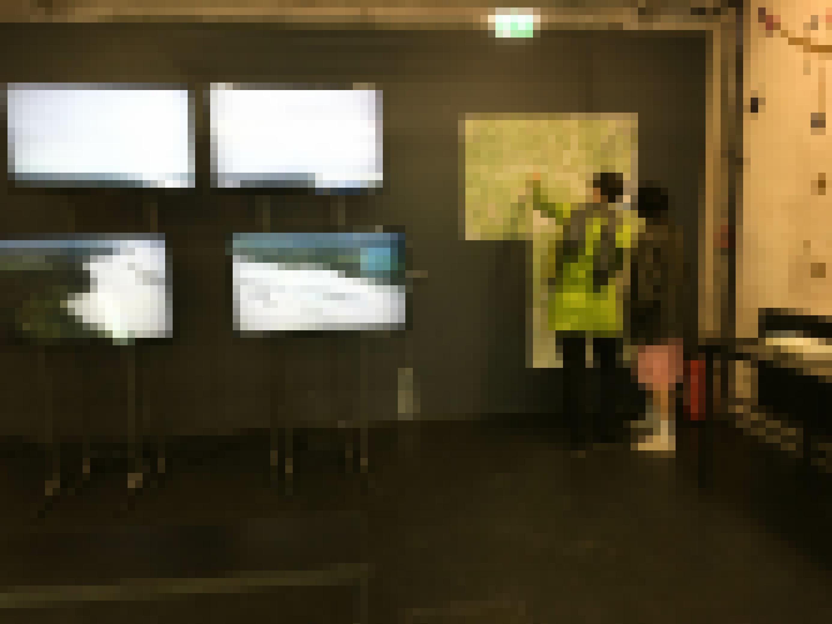 Bildschirme in Ausstellung, Landkarte, zwei Besucherinnen.