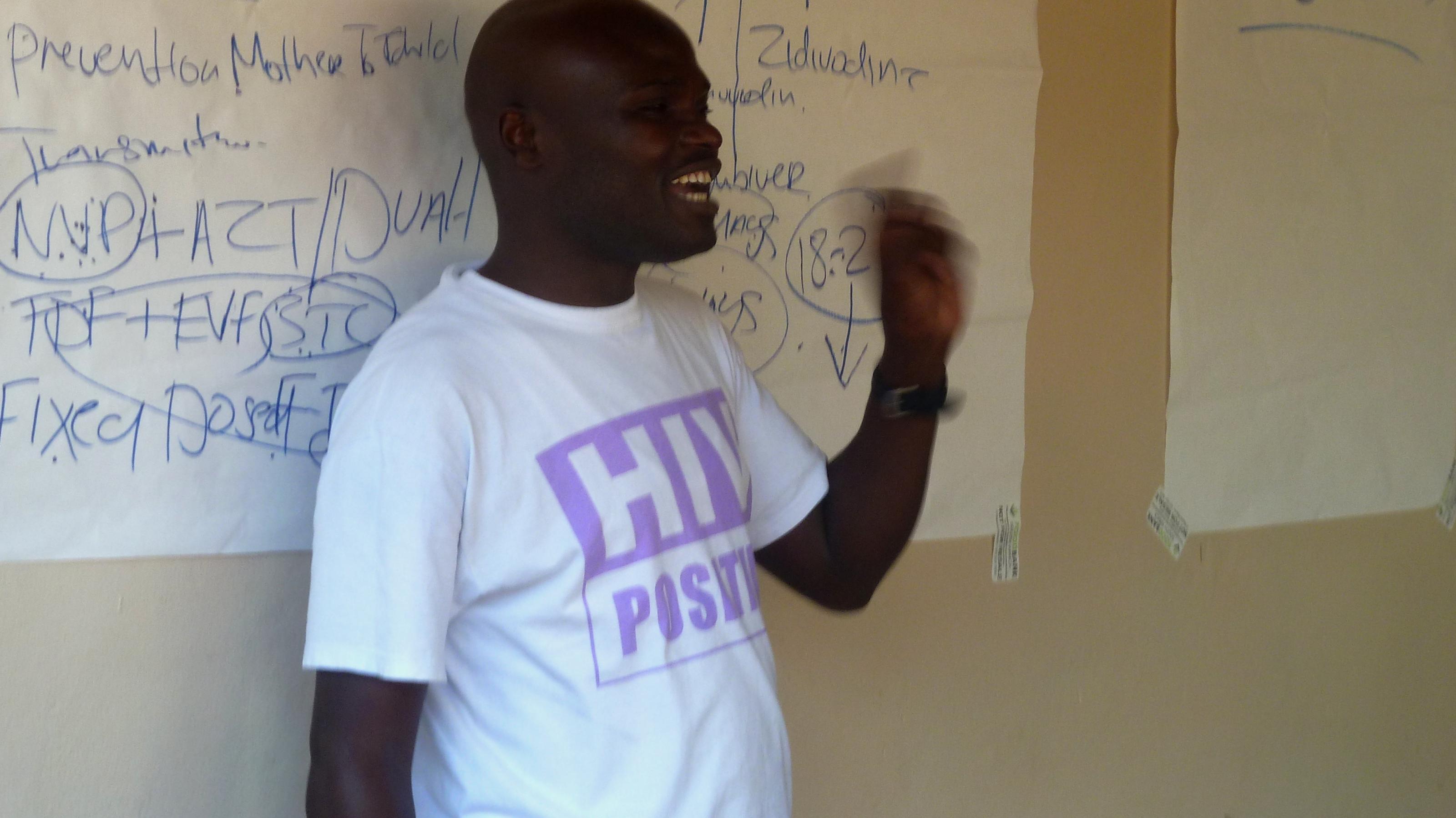 Ein Südafrikaner trägt ein T-Shirt mit der Aufschrift „HIV Positive“, mit einer Geste unterstreicht er, was er sagt, er klärt über HIV und Aids auf