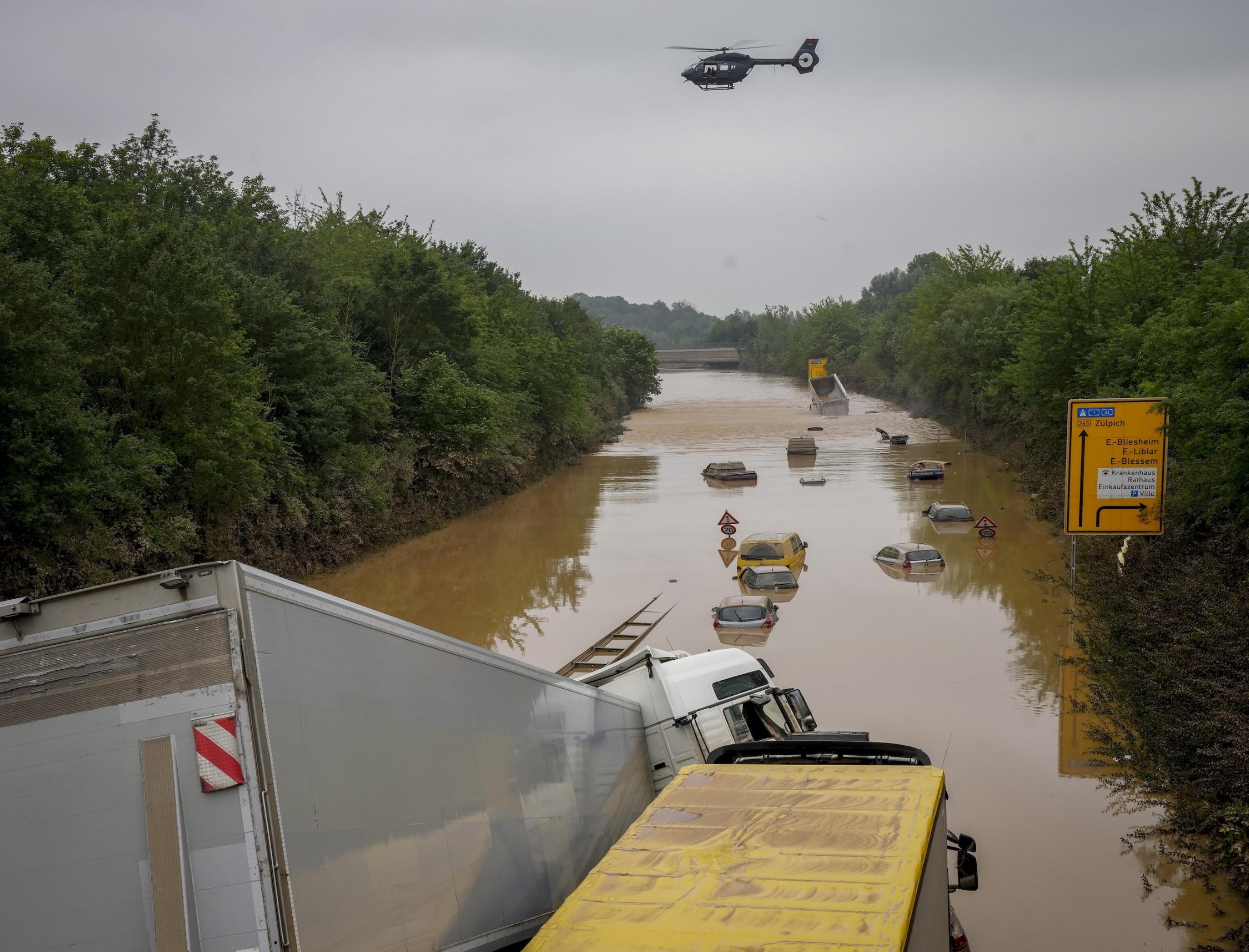 Die Bundesstraße ist komplett überschwemmt, leere Autos stehen im Wasser.