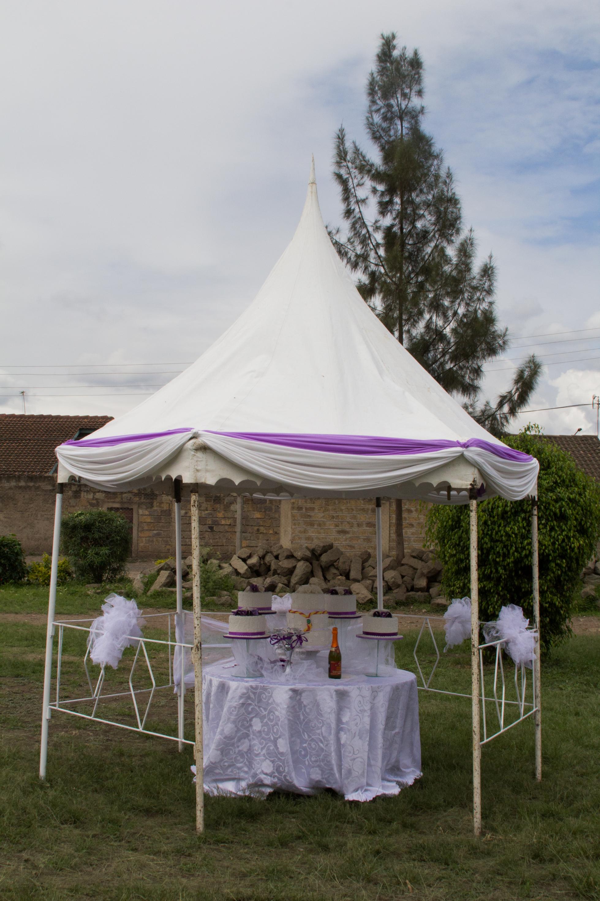 Mehrere Hochzeitstorten stehen auf einem Tisch und einem verzierten Pavillon.