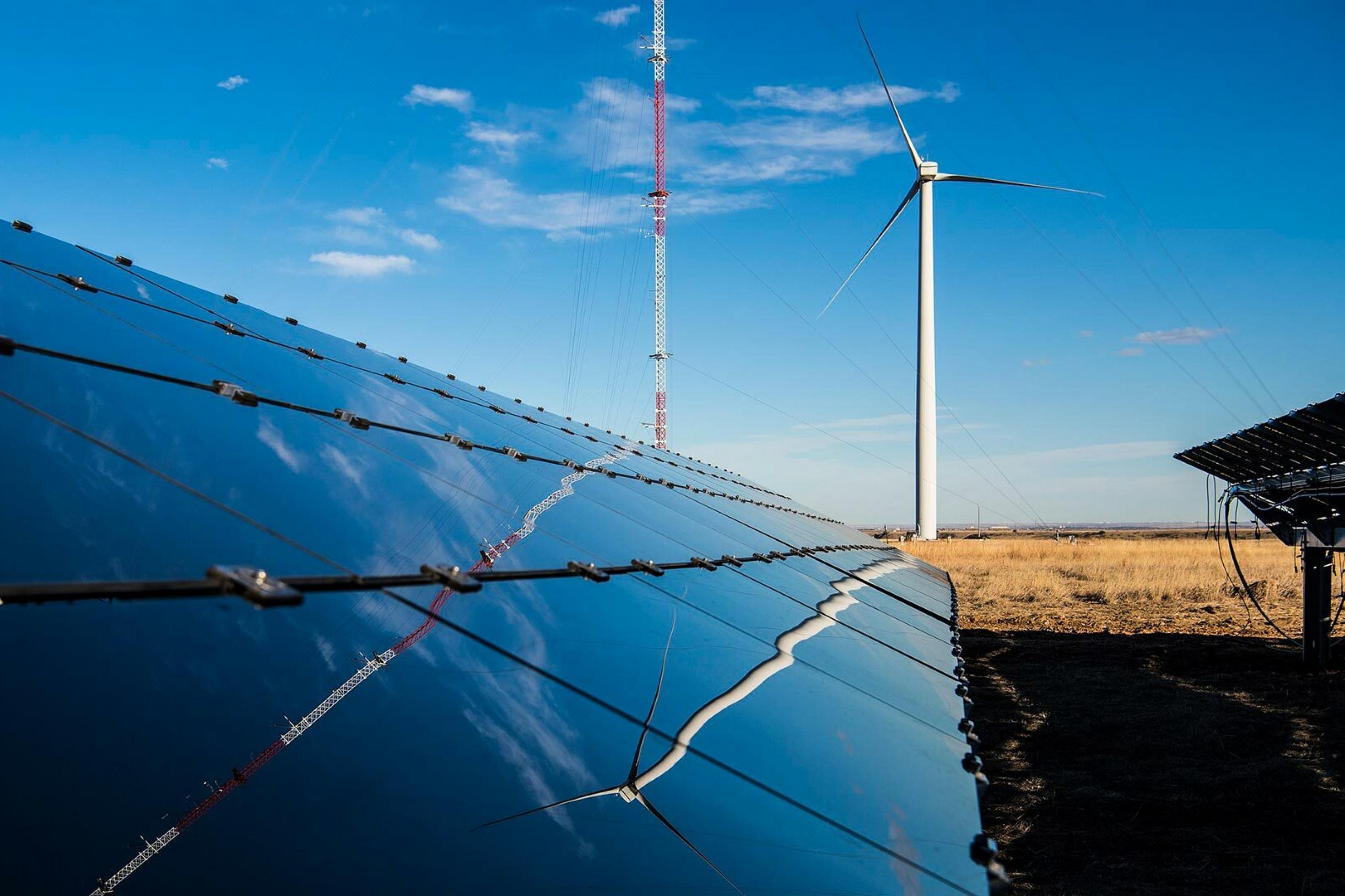Photovoltaikmodule und eine Windkraftanlage in einer Agrarlandschaft