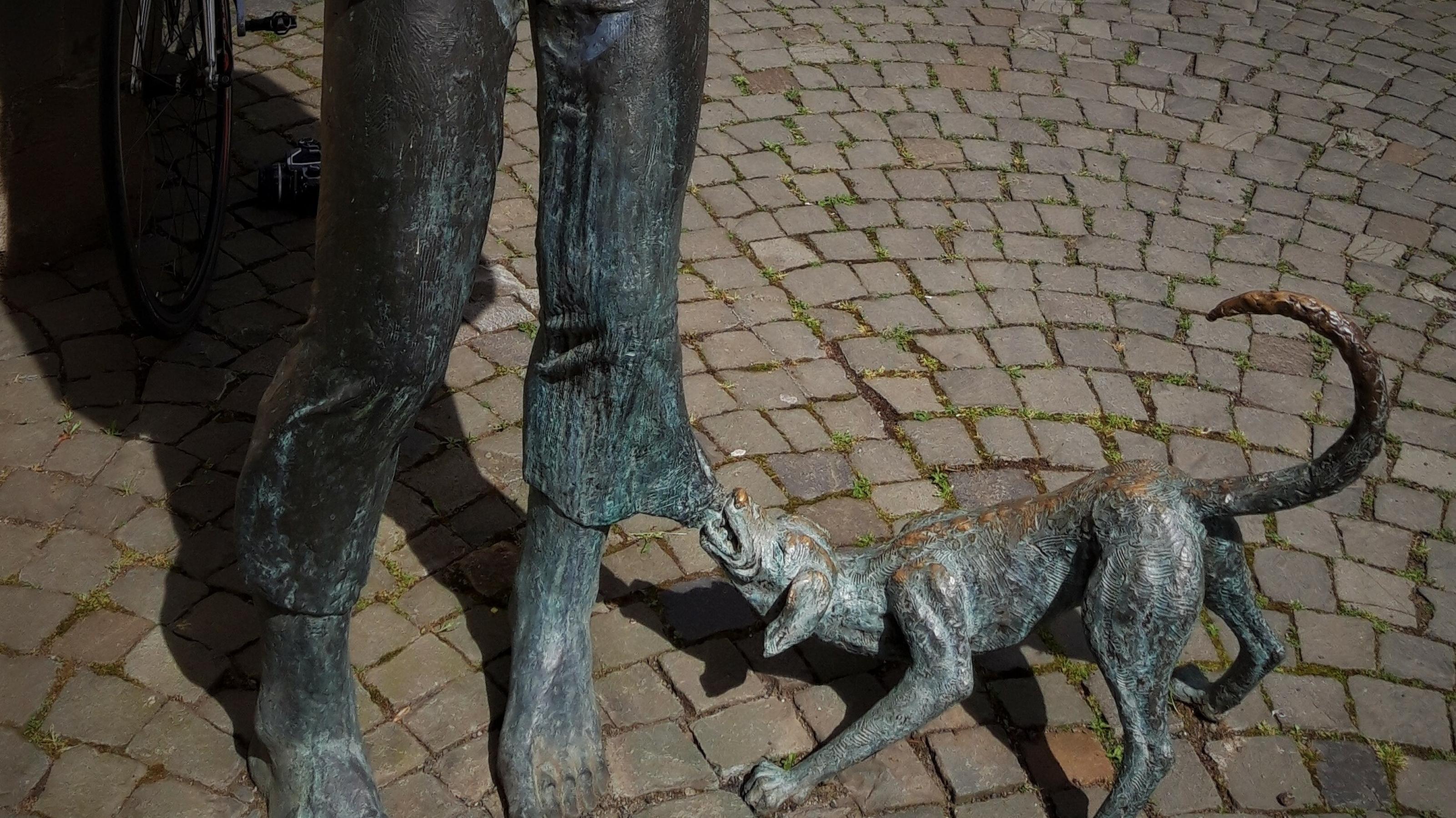 Im unteren Teil der Bad Kreuznacher Bronze-Plastik namens Dibbermann zerrt ein Hund am linken Hosensaum.