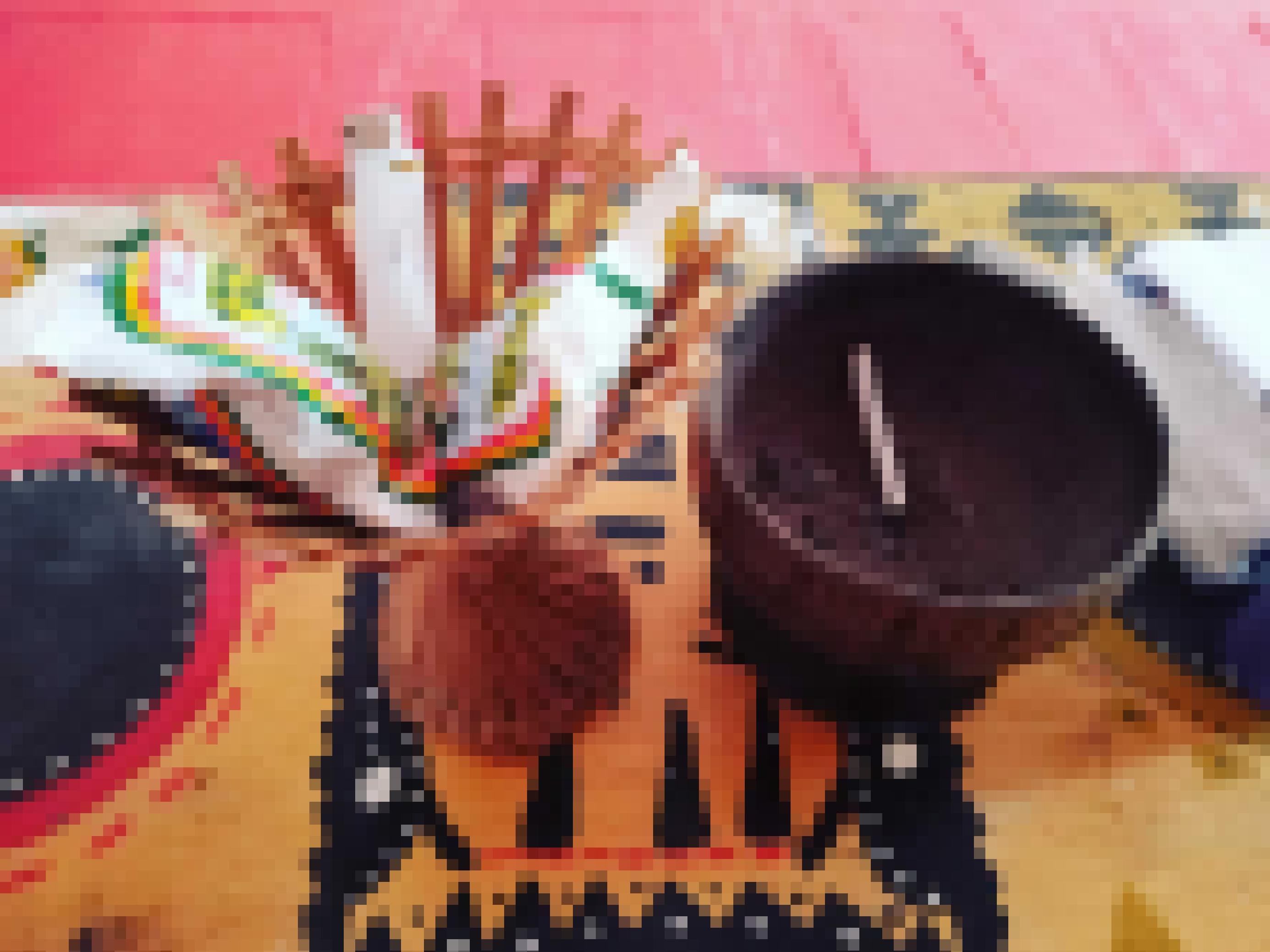 Auf einem mit geometrischen Mustern verziertem Tisch steht ein Aschenbecher aus Kokosnuss und ein geflochtener Korb mit zwei Plastiktütchen voll Tabak und einem Feuerzeug.