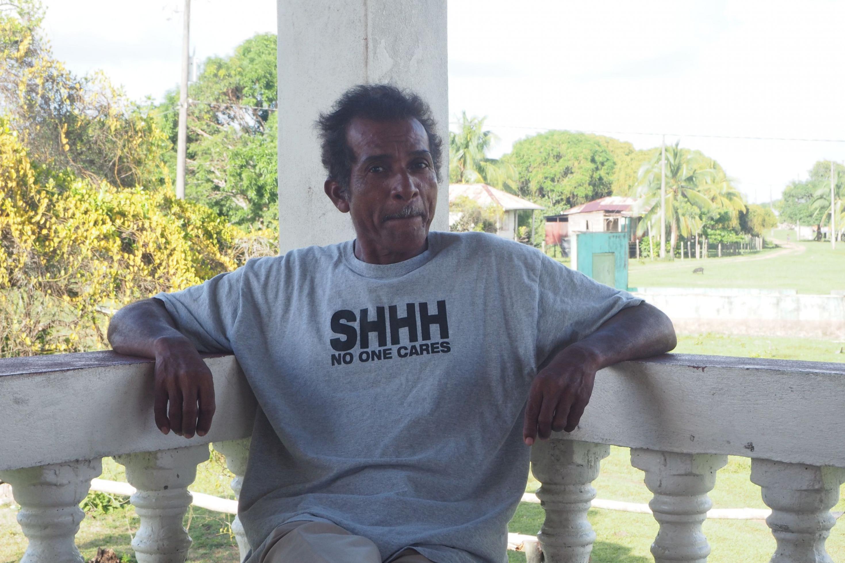 Mann blickt skeptisch in die Kamera. Auf seinem T-Shirt steht: „No one cares“