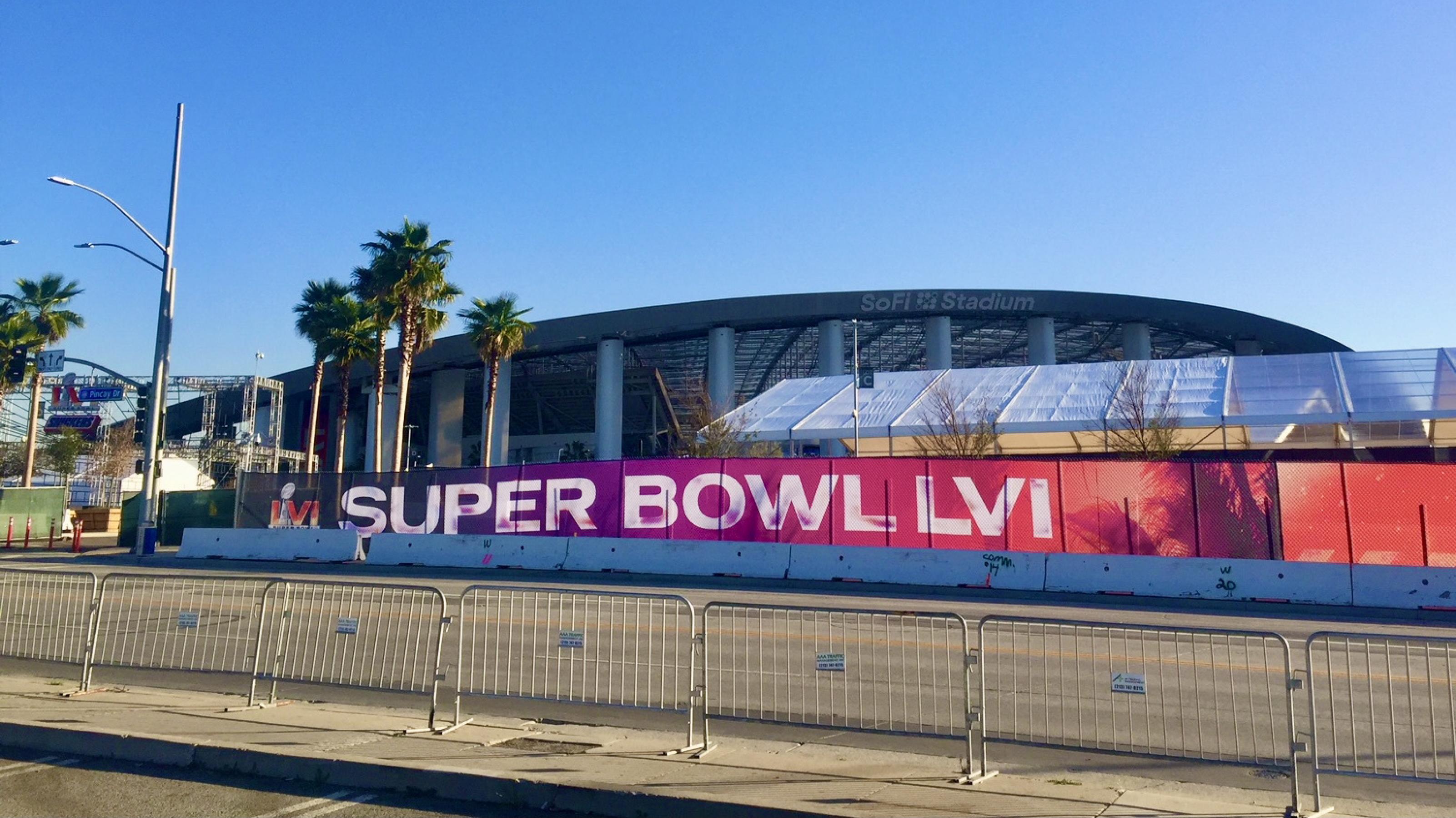 Absperrungen, Zelte, Palmen und im Hintergrund das teuerste Footballstadion der Welt unter wolkenlosem Himmel: SoFi Stadion, Los Angeles