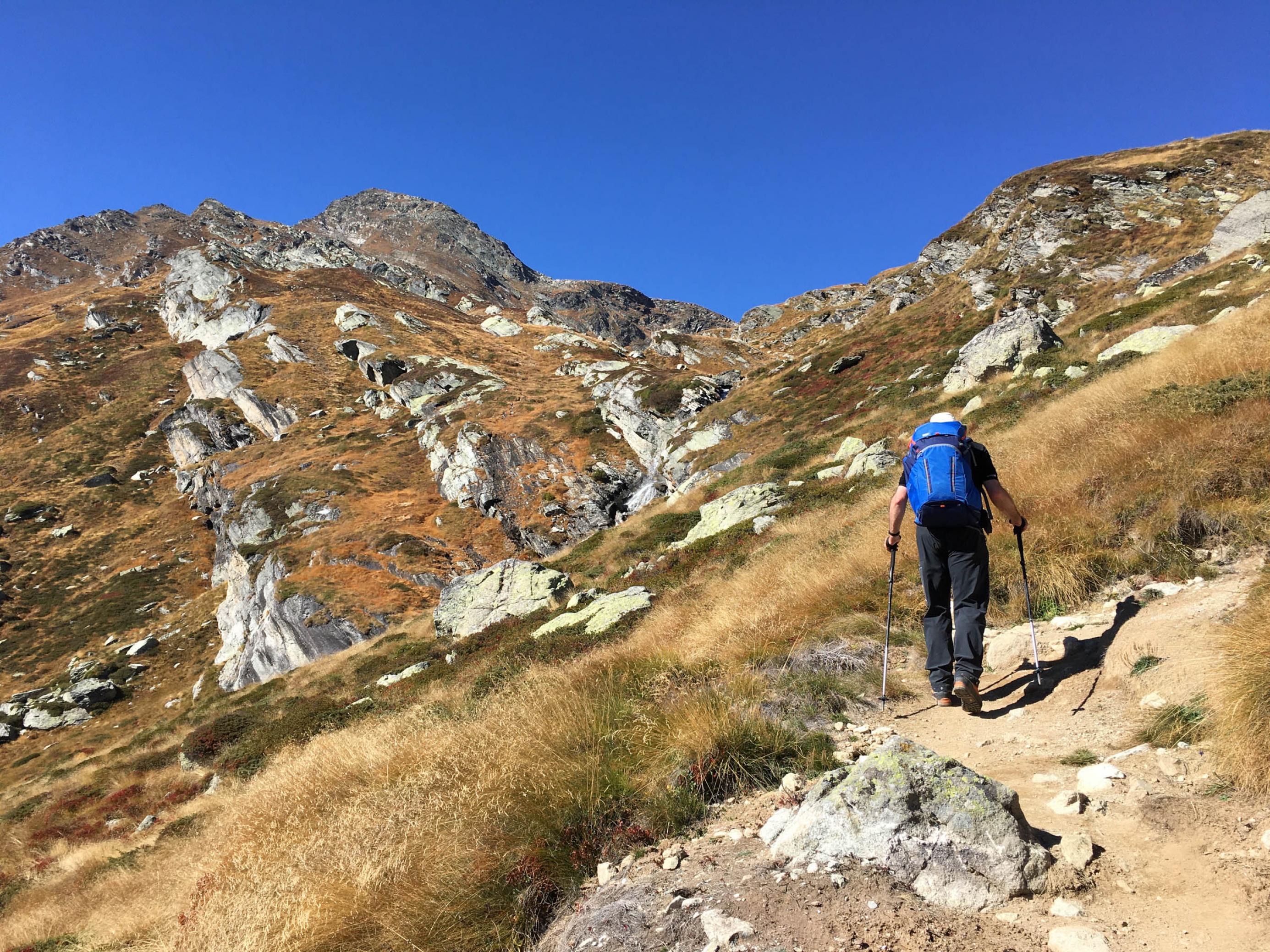 Steiler Wanderweg im Gebirge, Wanderer geht hinauf