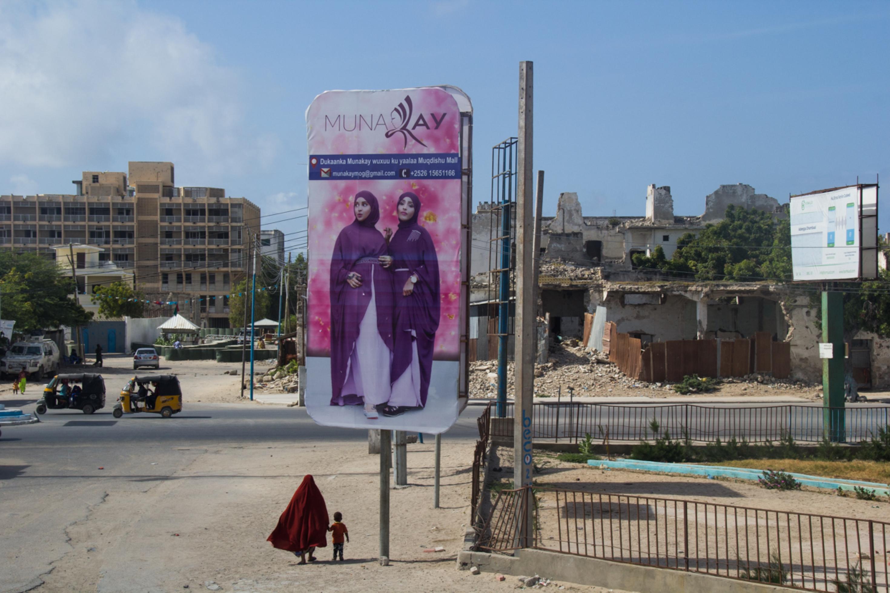 Eine monumentale Werbetafel zeigt in der Innenstadt von Mogadischu Mode für Frauen. Dabei sind die Kriegsschäden noch nicht beseitigt.