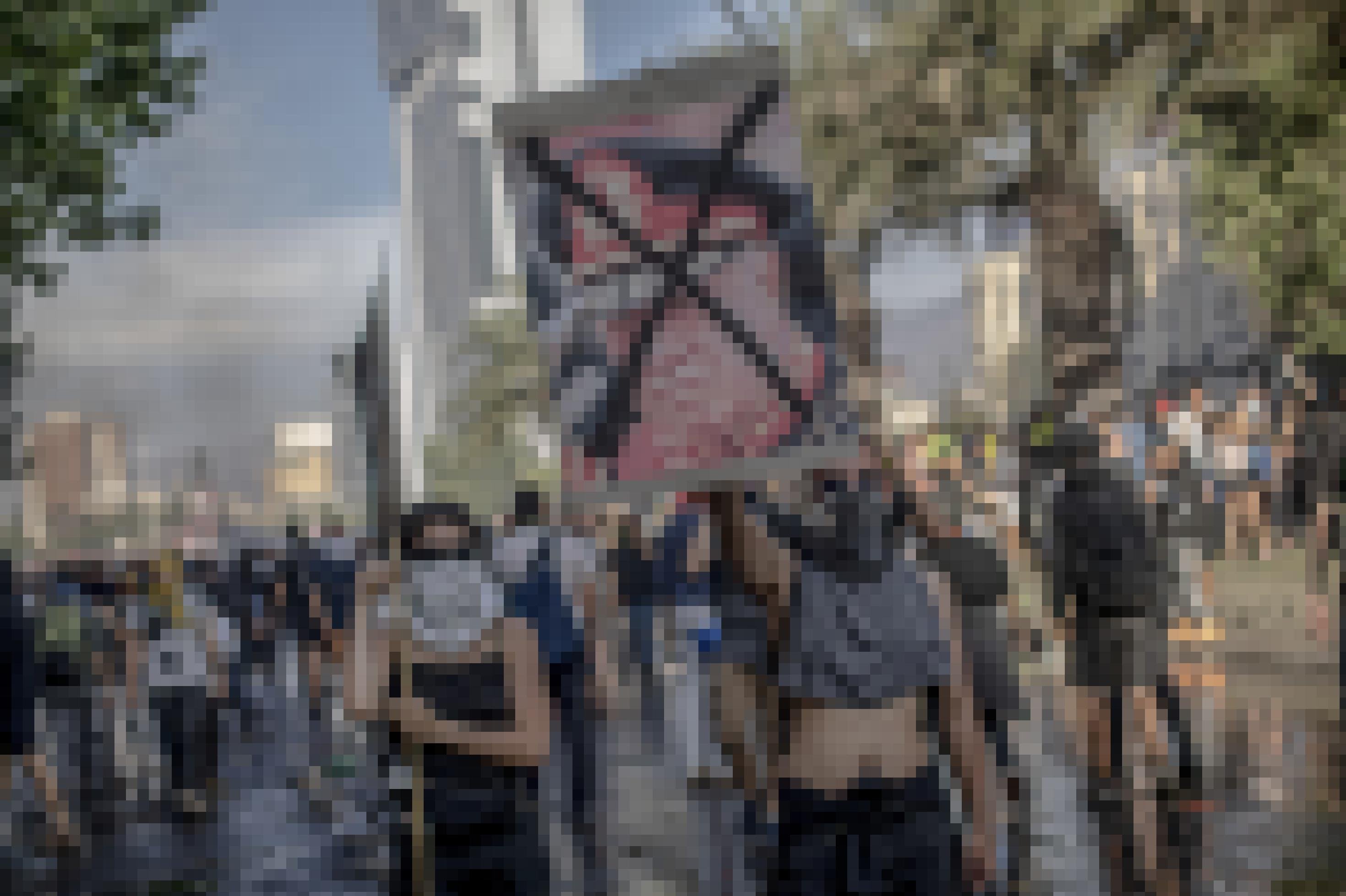 Demonstrantïnnen halten ein Schild mit dem durchgekreuzten Gesicht von Pinochet hoch.
