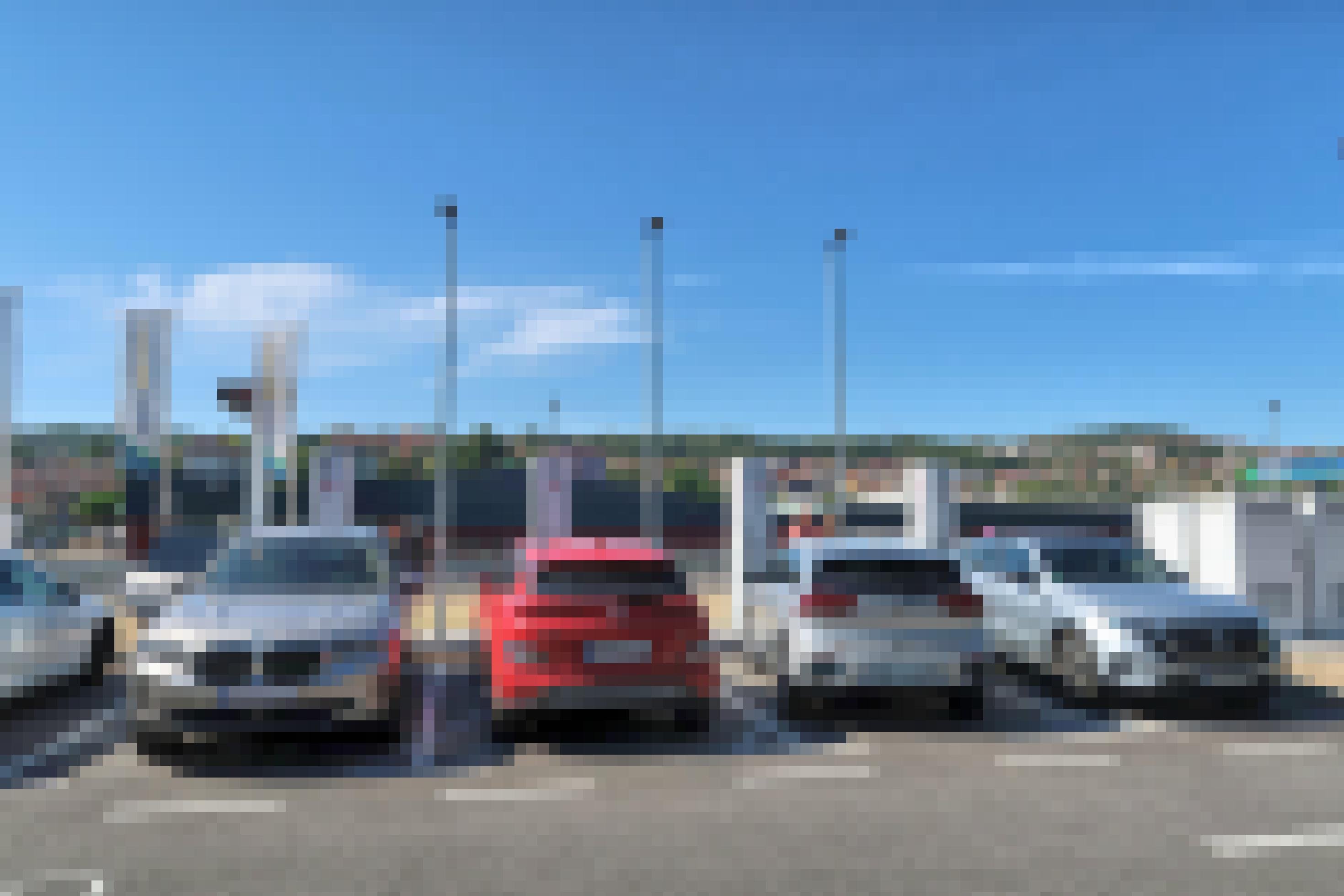 Vier Elektroautos laden nebeneinander Strom auf einem Parkplatz