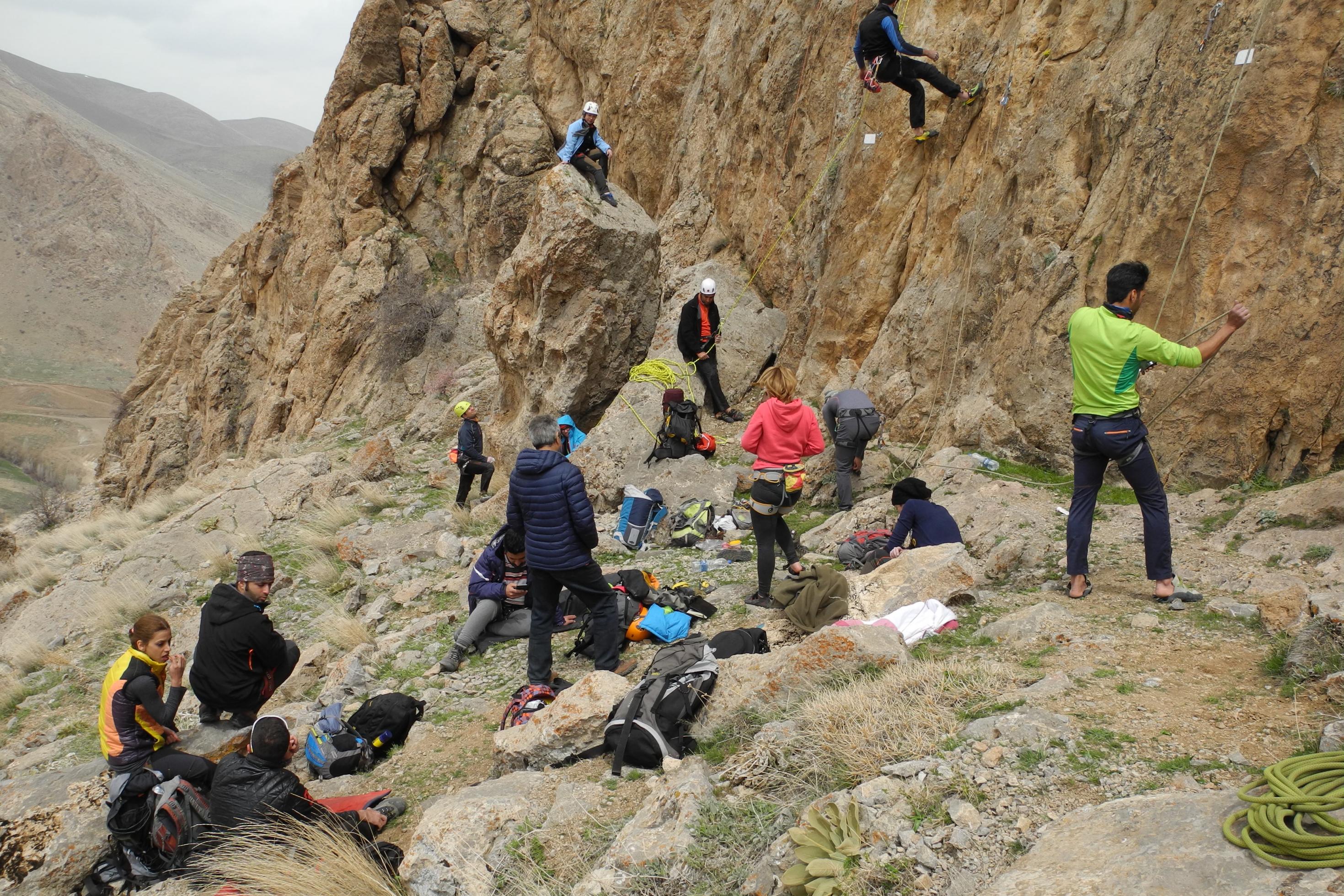 Junge Iraner und Iranerinnen klettern gemeinsam an einem Felsen im Nordwesten des Landes.