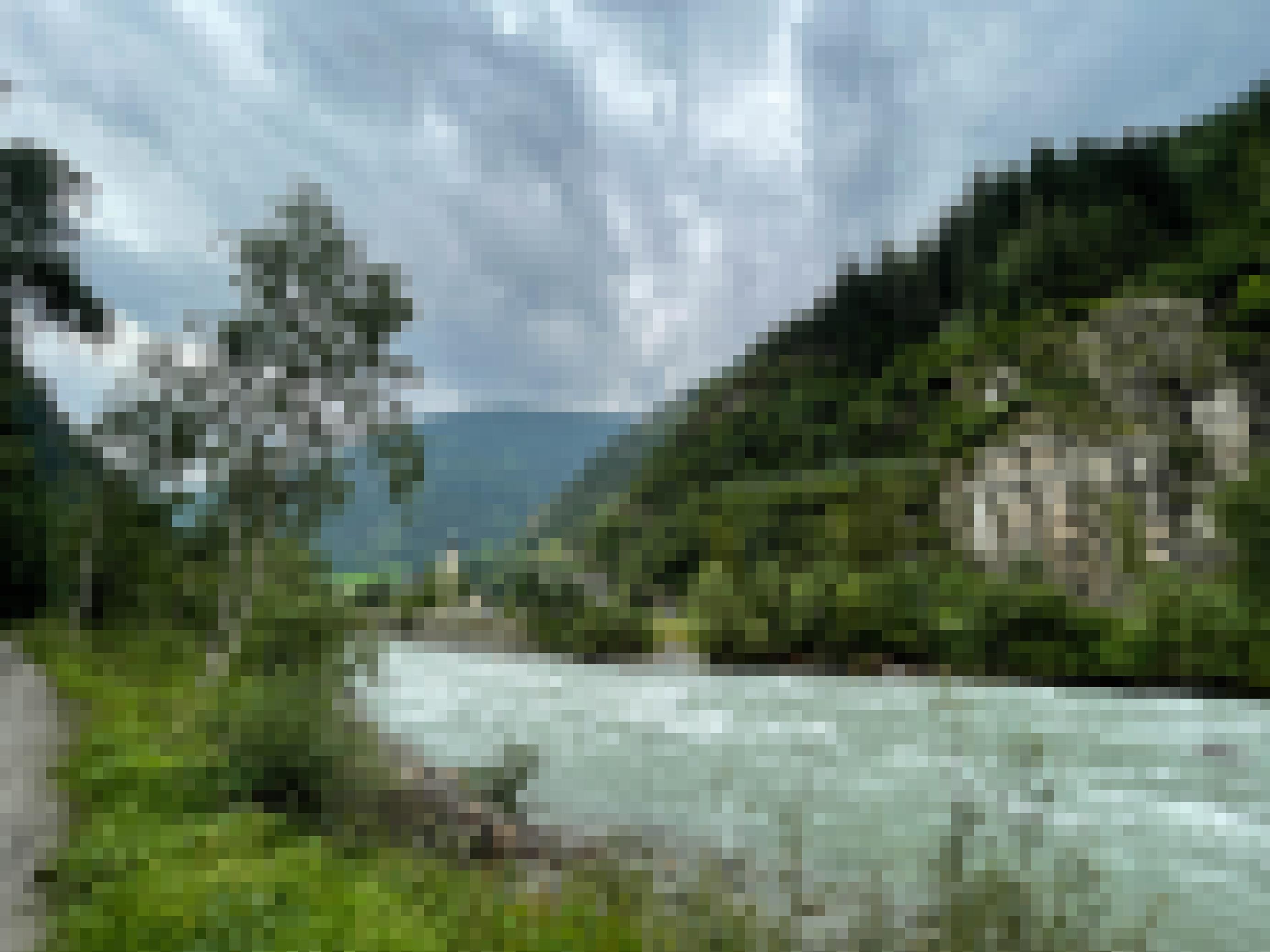Fluss vor Felswand, links ein kleines Dorf