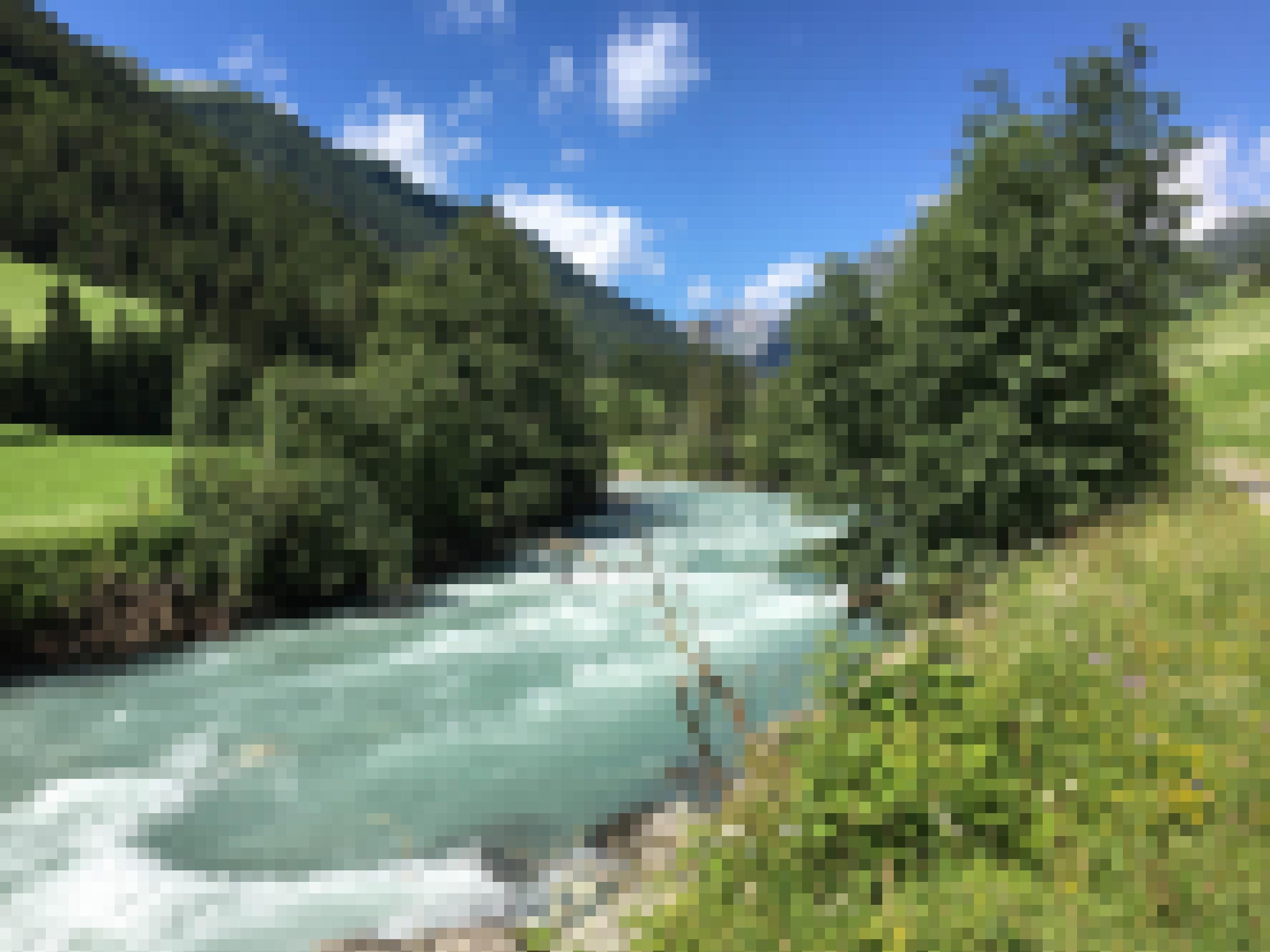 Türkisfarbener Fluss, blauer Himmel mit Wolken, grüne Landschaft