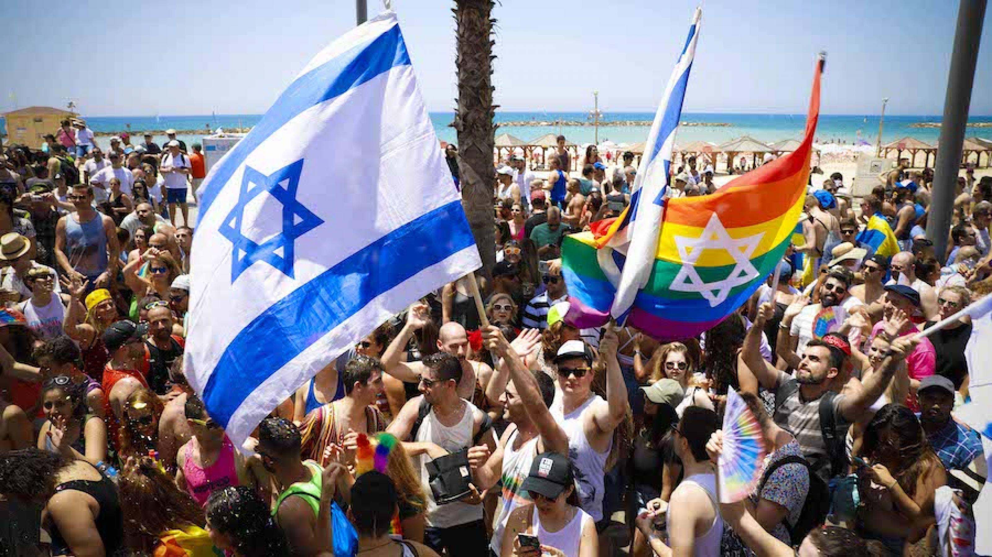 Menschen schwenken Regenbogen- und Israelfahnen in Tel Aviv