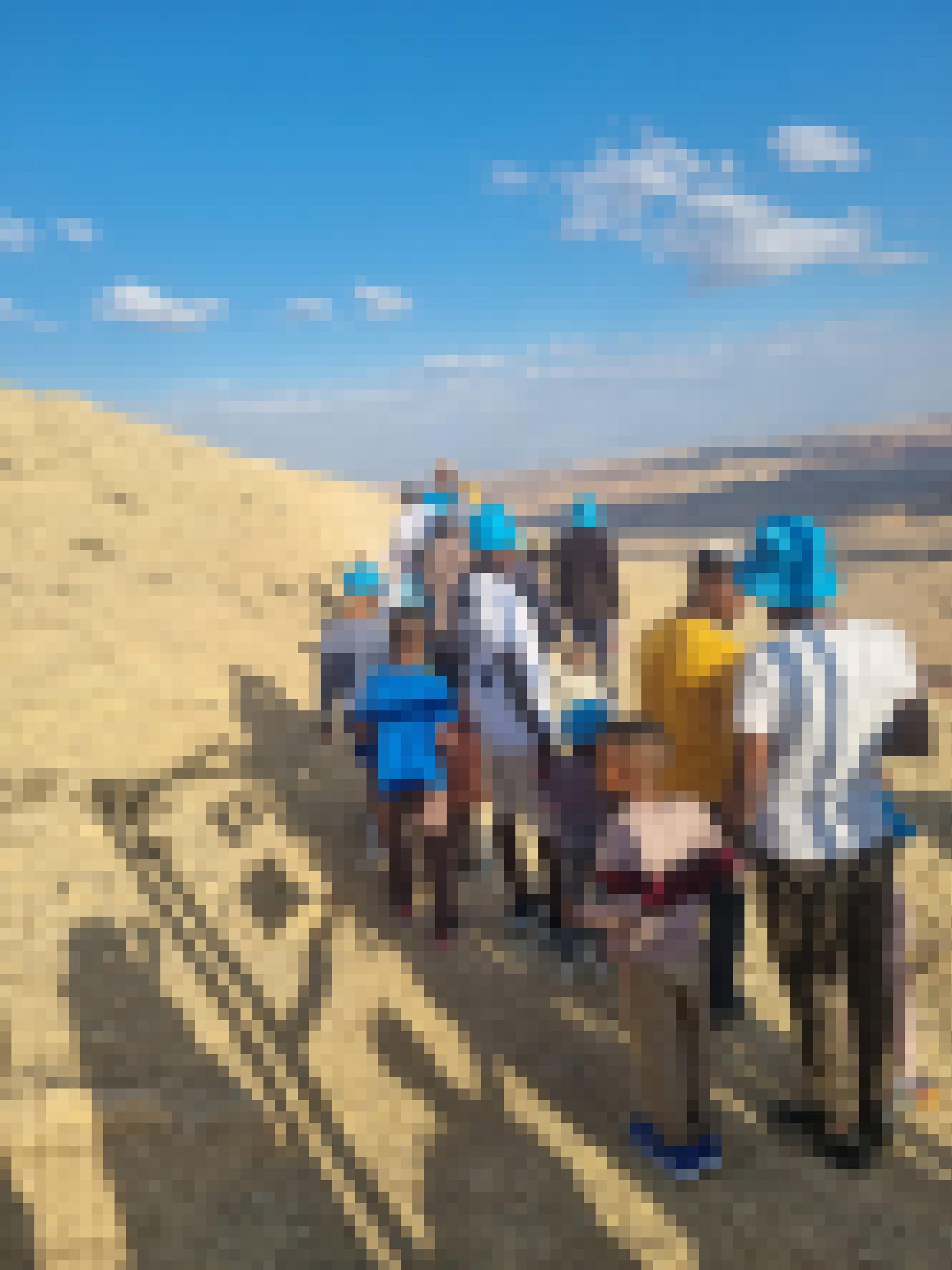 Eine Gruppe Menschen auf einem schmalen Pfad in der Wüste