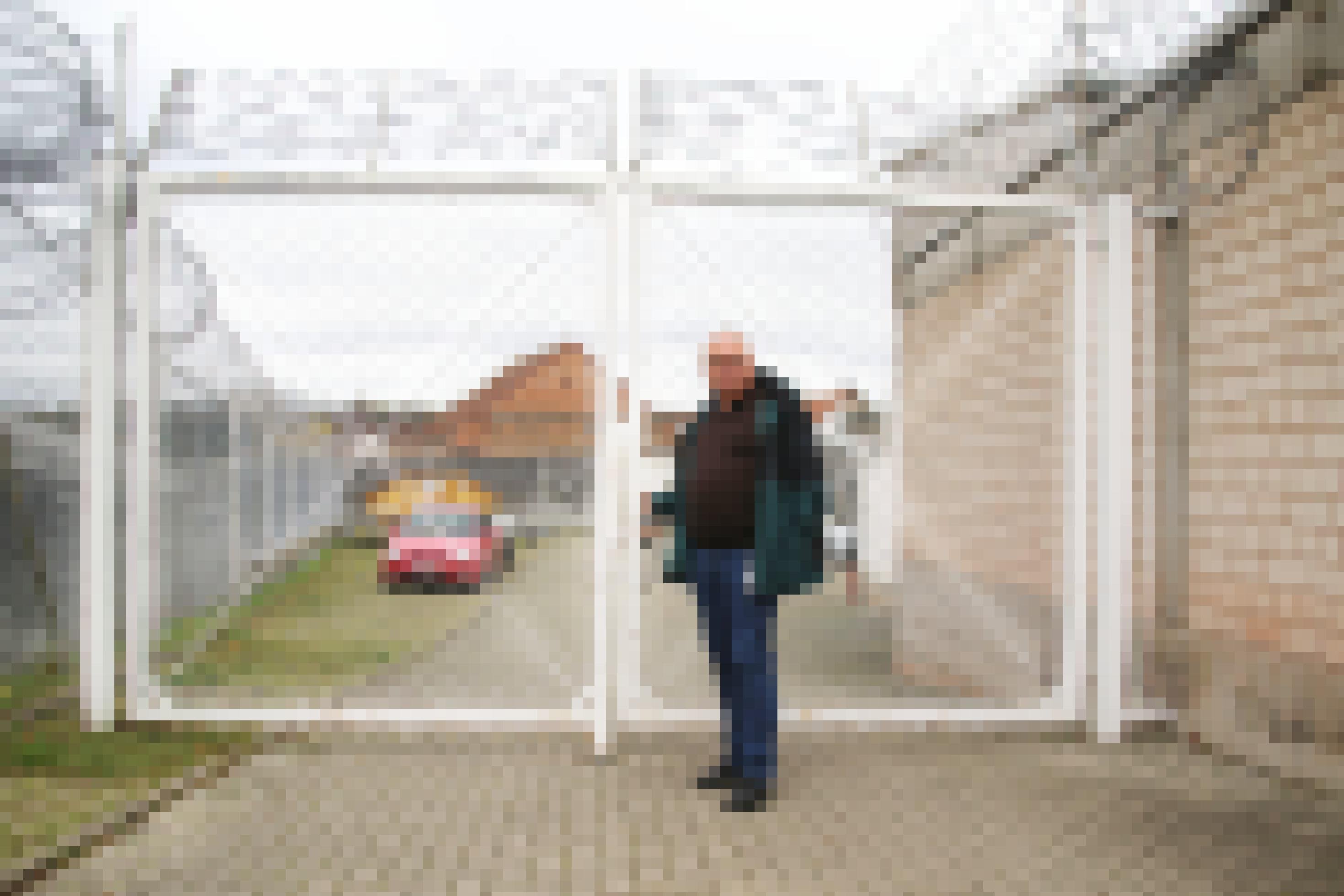 JVA-Leiter Jürgen Buchholz steht vor einem Tor mit Stacheldraht