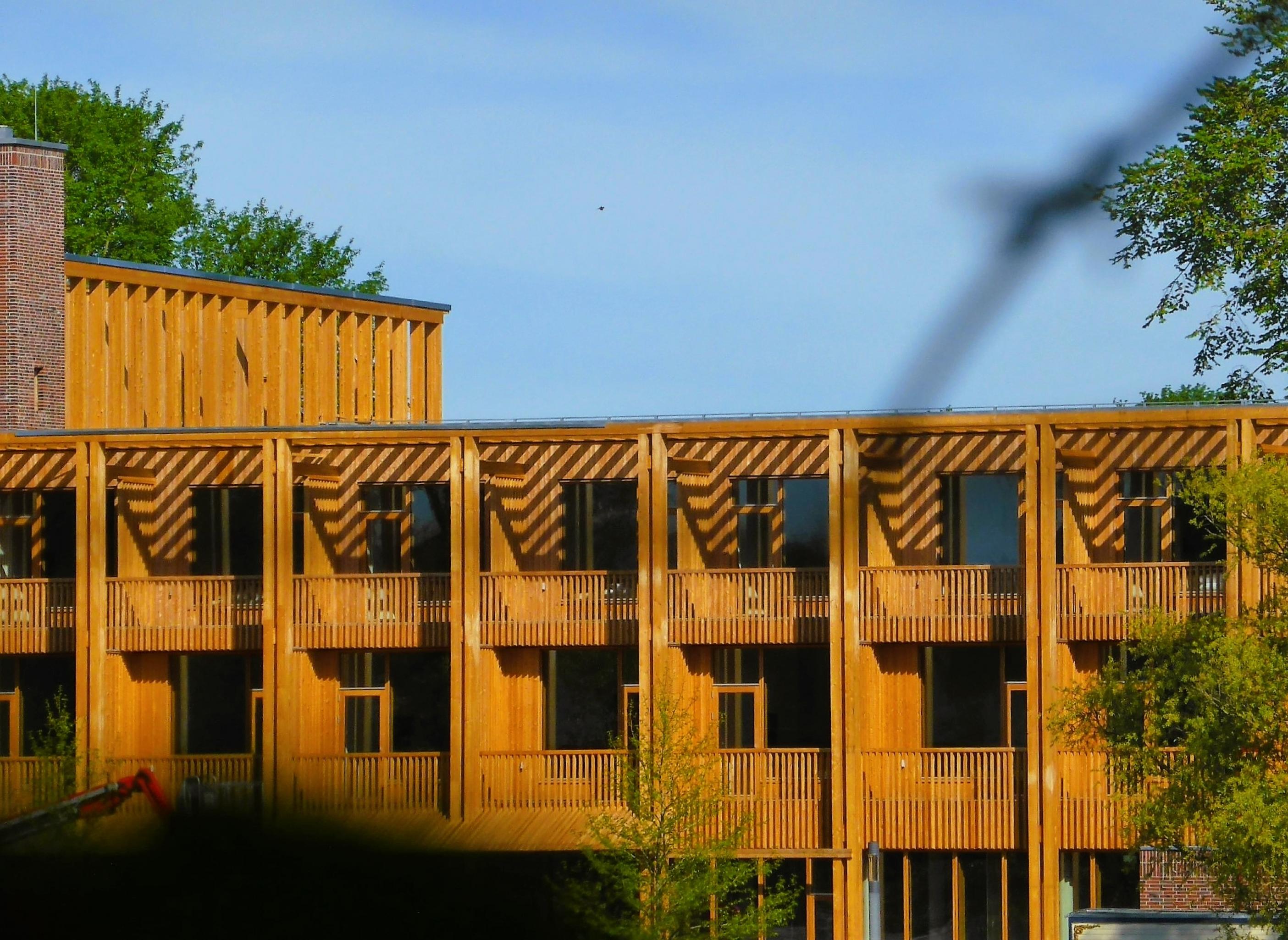 Rechteckige Winkel prägen die Holzfassade des Hotels, aber die hellbraunen Lamellen zeichnen eine warme Ansicht des innovativen Hotels.