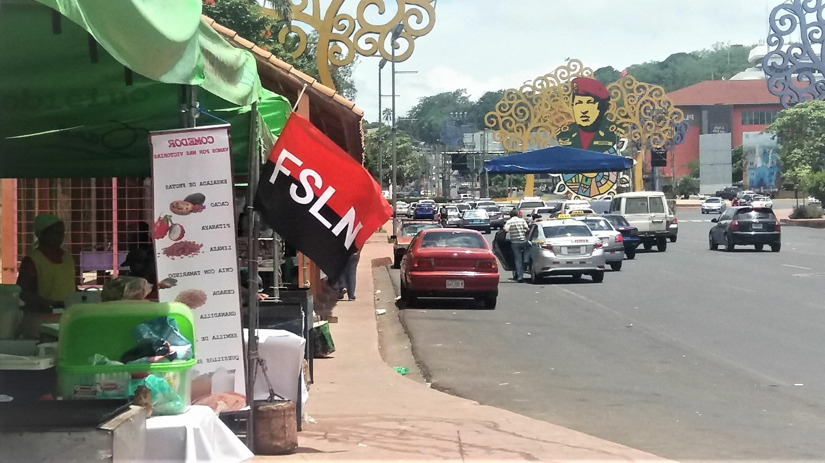 Die schwarz-tote Fahne der Sandinistischen Befreiungsfront FSLN hängt an einem Kiosk am Rande einer großen Straße