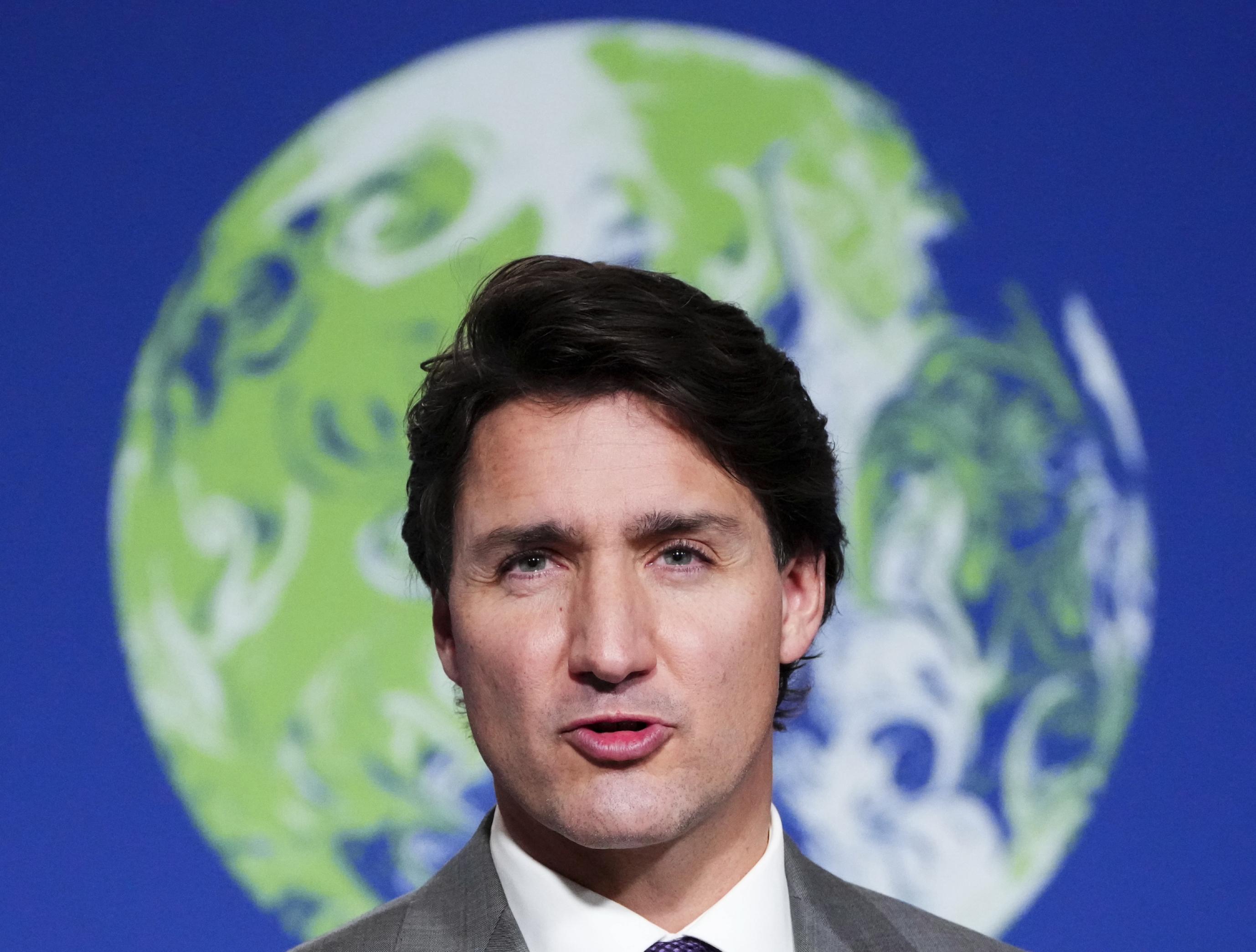 Trudeau-Porträt vor einer Weltkugel, er sieht entschlossen drein.