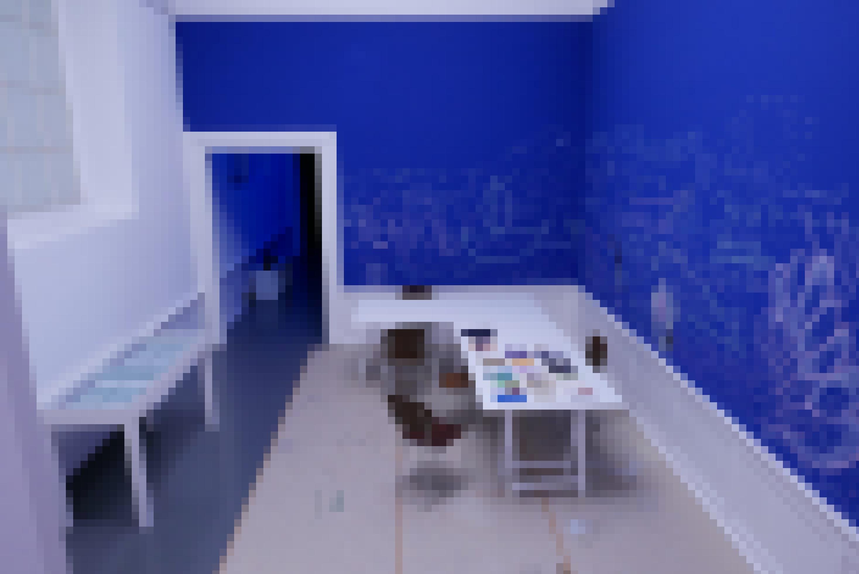 Ein Tisch mit Stühlen vor einer blauen mit Mindmaps und Gesprächsnotizen bedeckten Wand.