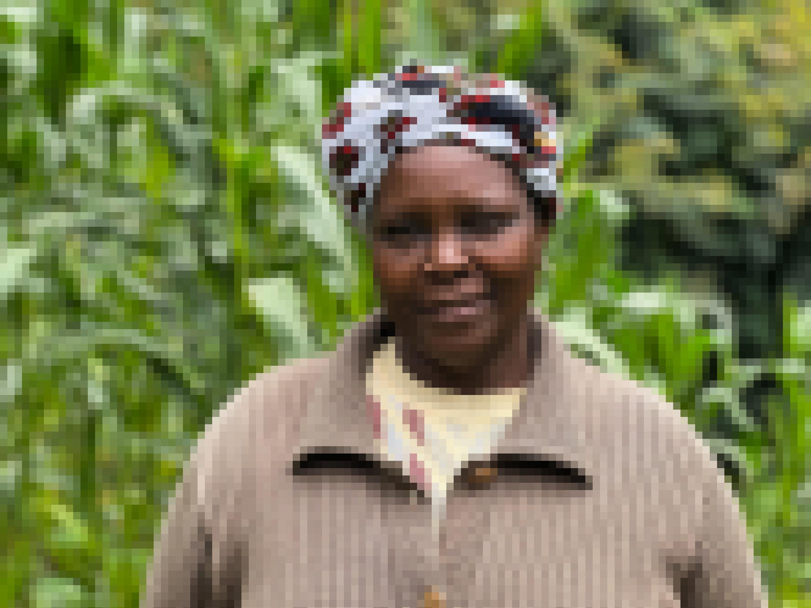 Ein Portrait der Bäuerin Lucy Muigai. Sie guckt freundlich in die Kamera, im Hintergrund ihre kräftig stehenden Maispflanzen.