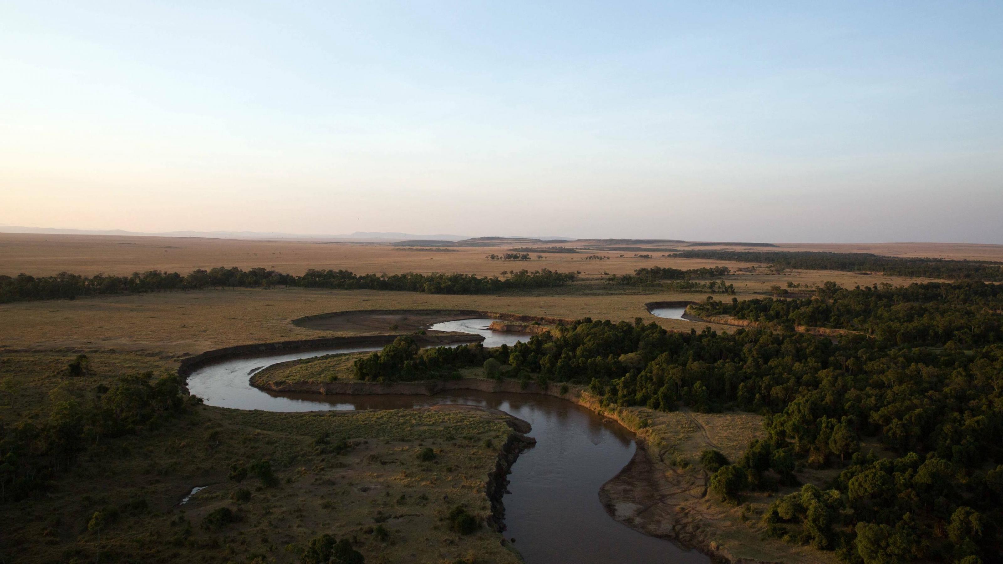 Die Aufnahme wurde aus der Luft gemacht, im Abendlicht. Zu sehen sind der Mara-Fluss und die Weite des Nationalparks.