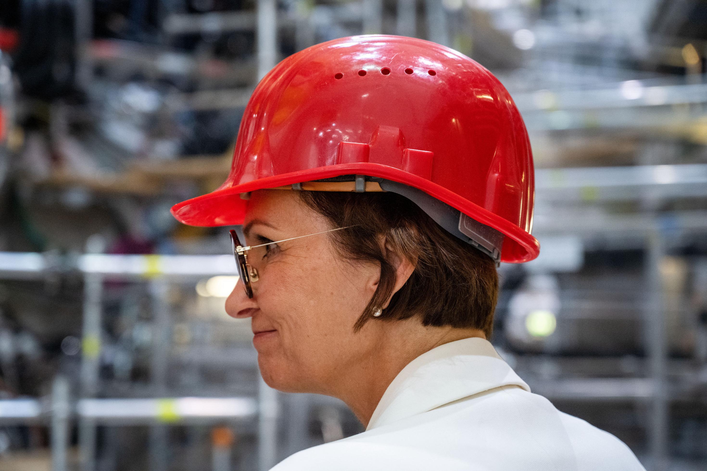 Die Politikerin mit rotem Helm for technischem Gerät.