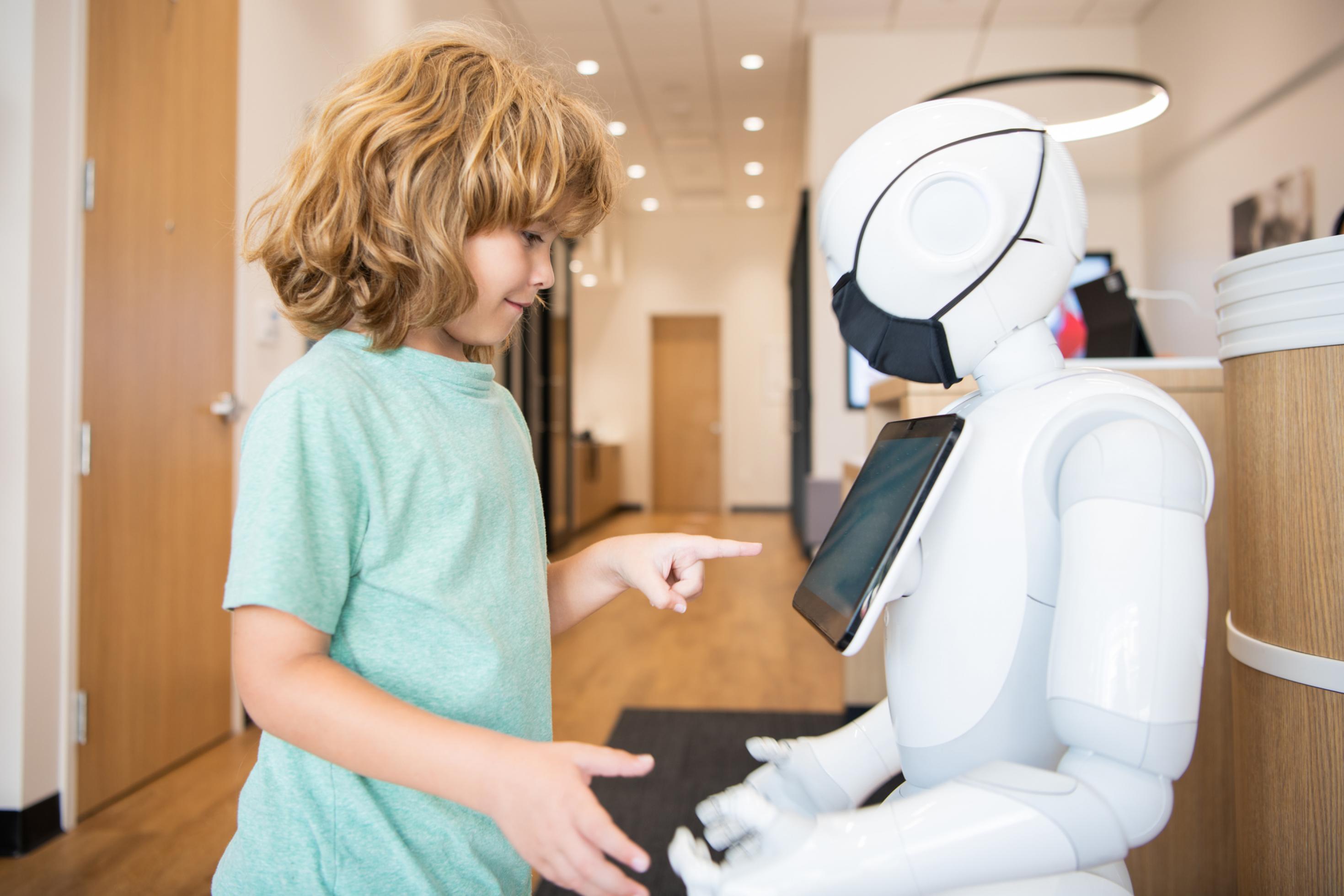 Junge bedient mit Roboter, der mit künstlicher Intelligenz kommuniziert