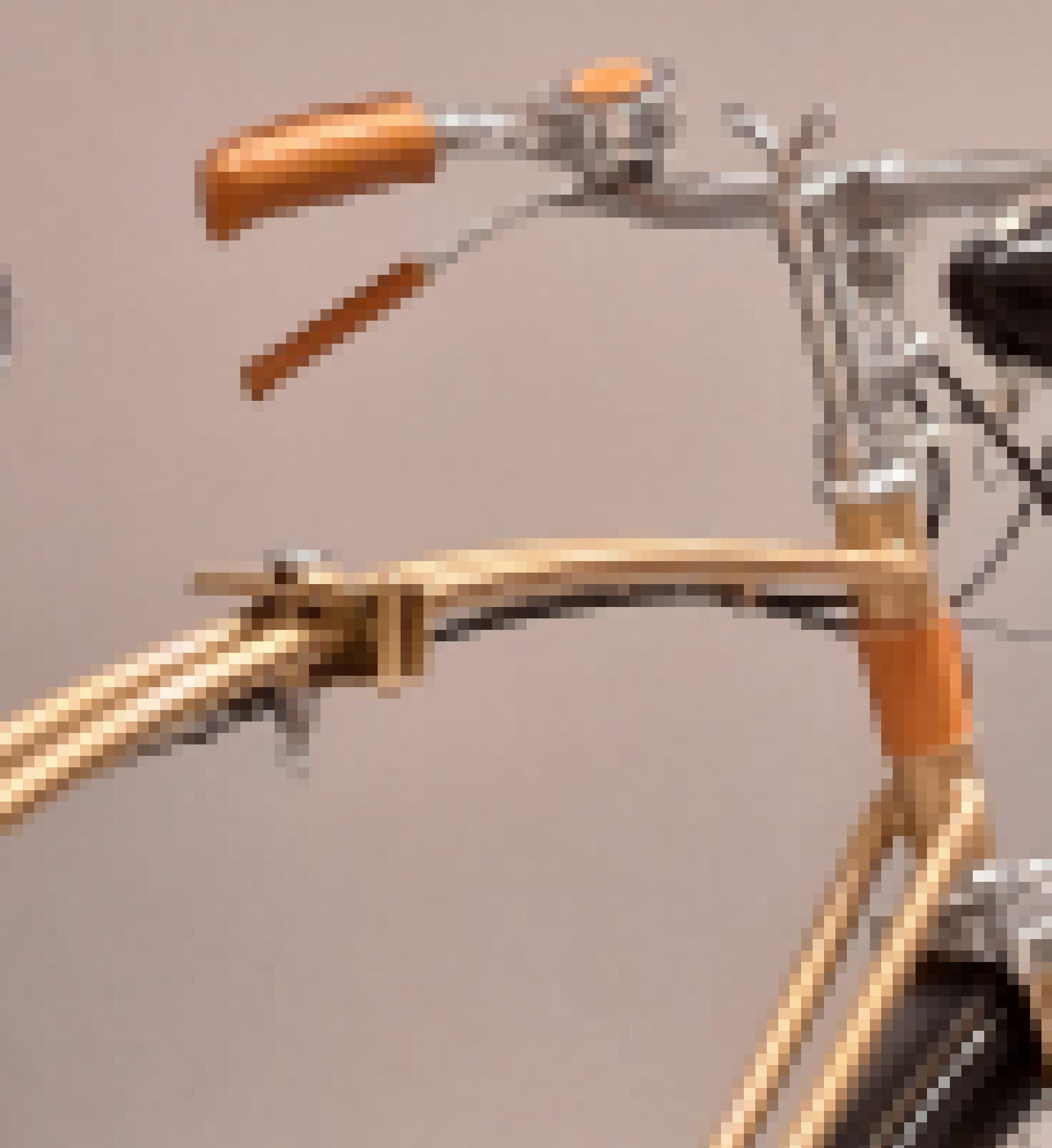 Detailaufnahme von Lenker und Querstange des goldglänzenden Fahrrads, die eine Flügelschraube zum Zusammenklappen trägt.