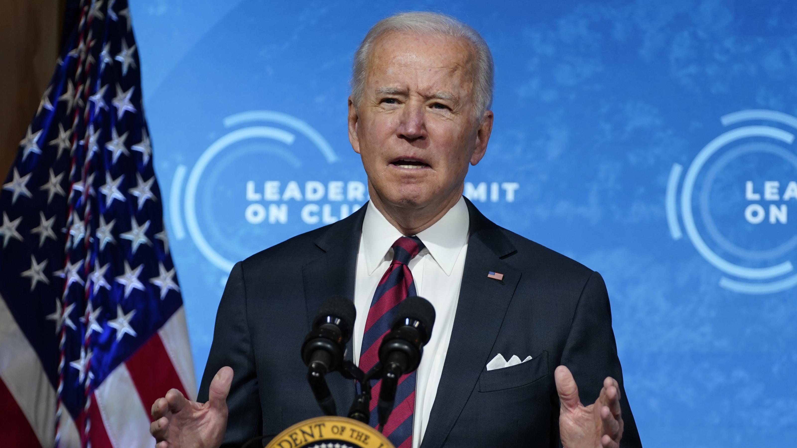 Biden mit dem Logo des Leaders Summit on Climate und der US-Flagge im Hintergrund.