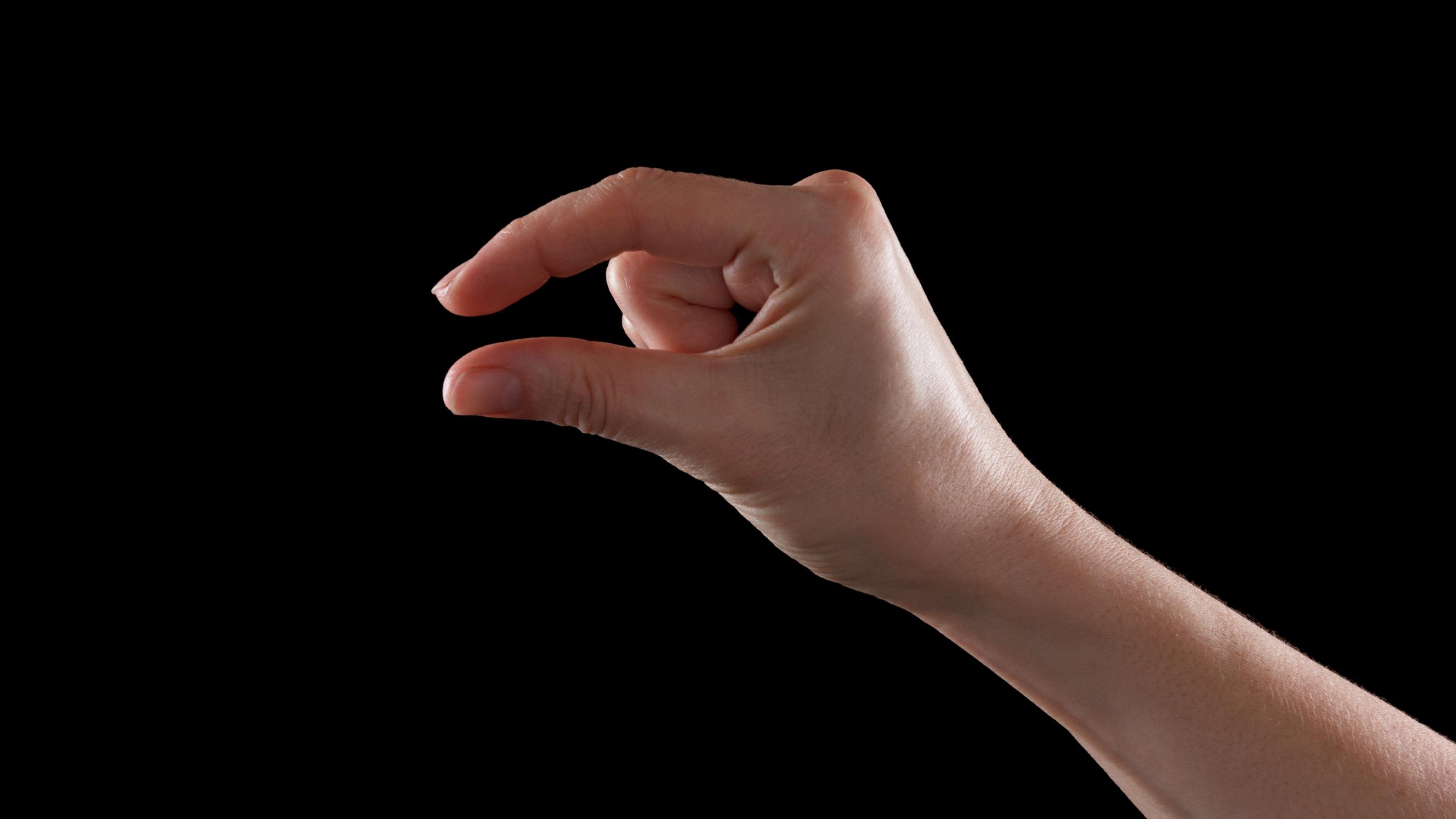 Eine Frauenhand hält die Finger nahe zusammen, um „klein“ zu signalisieren.