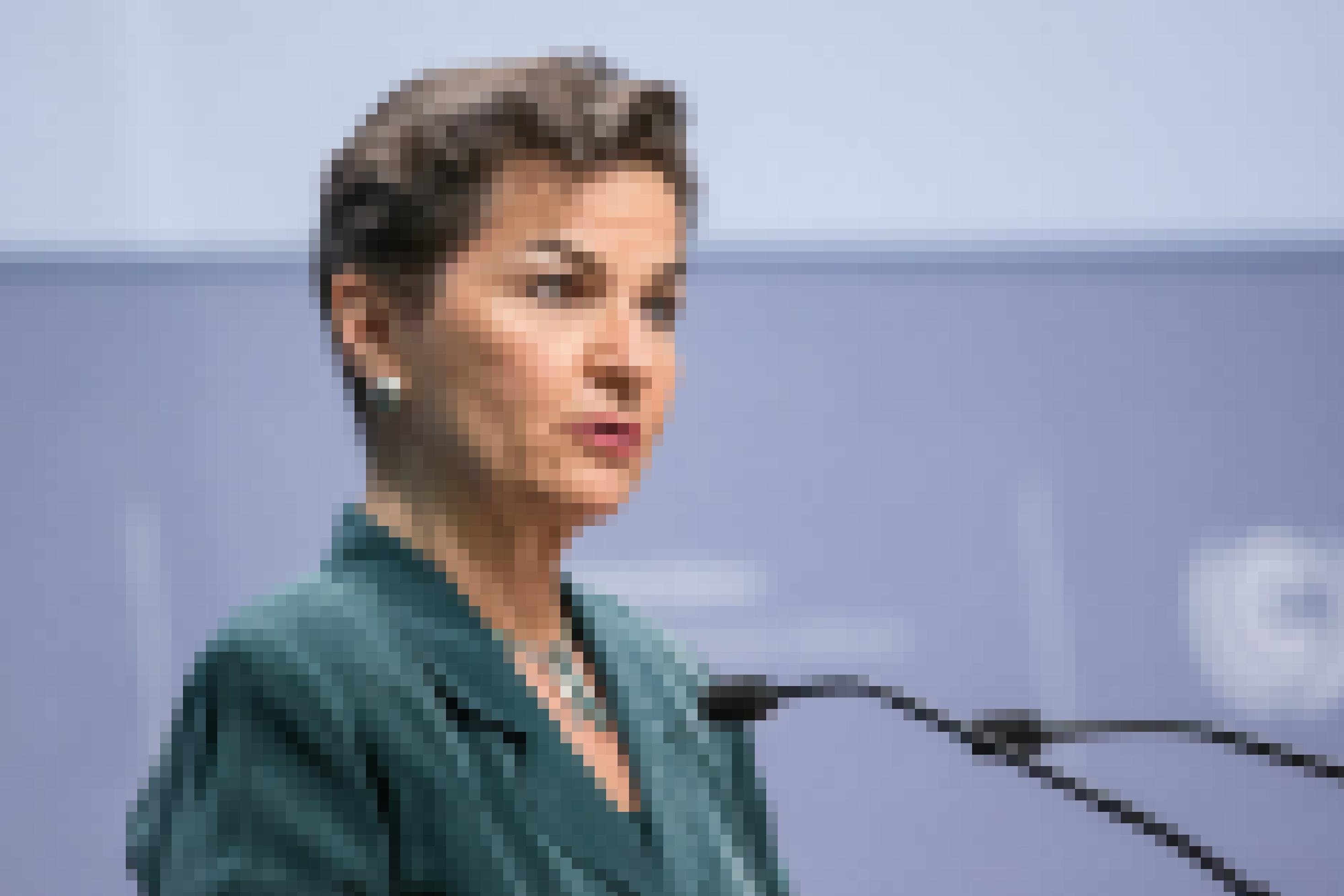Christina Figueres, eine Frau in ihren Sechzigern mit einem Kurzhaarschnitt, mit entschiedenem Gesichtsausdruck an einem Rednerpult