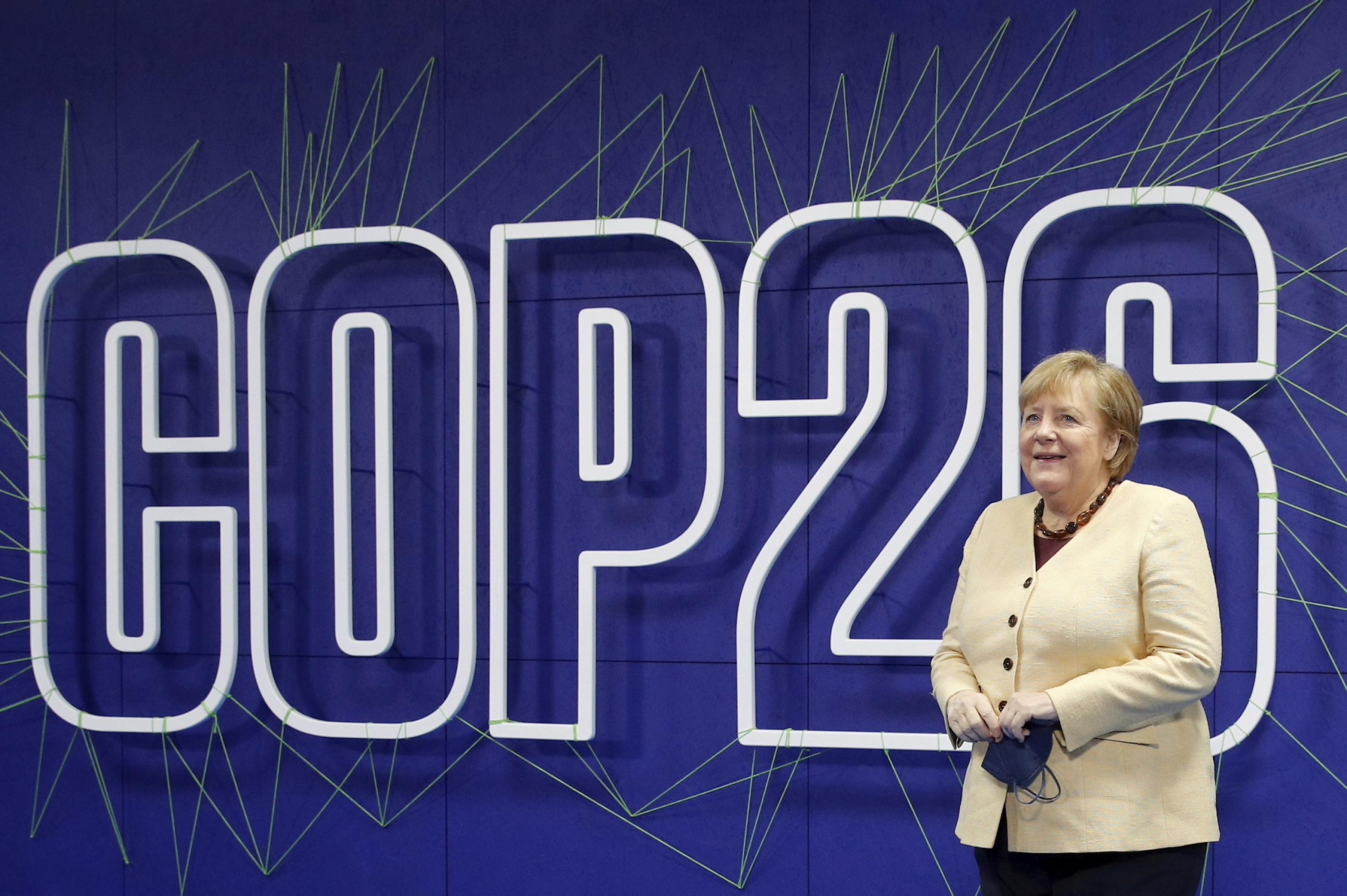 Merkel vor einem Schriftzug „COP26“