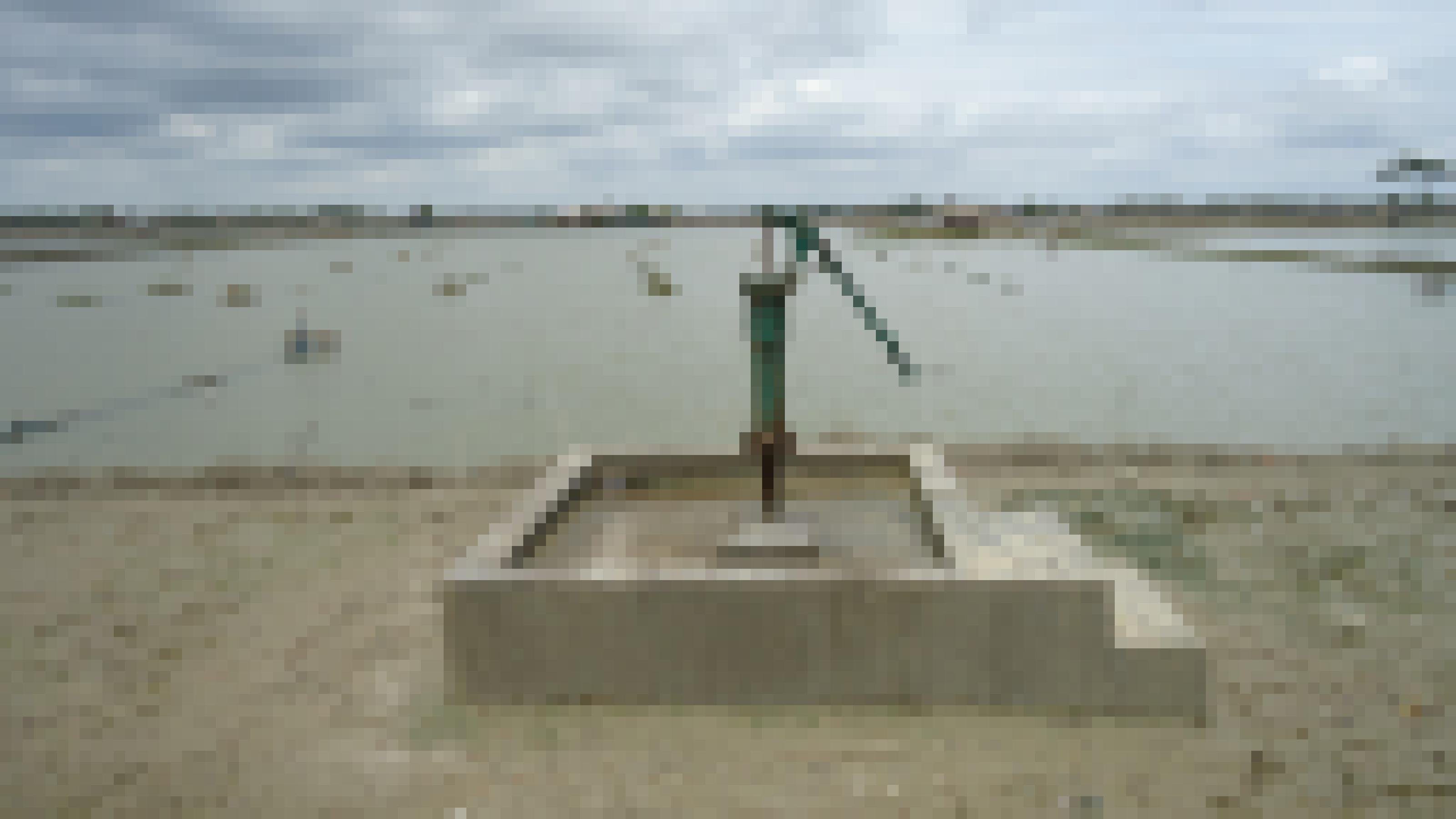 Ein Betonbrunnen vor grauem Wasser, Bangladesch