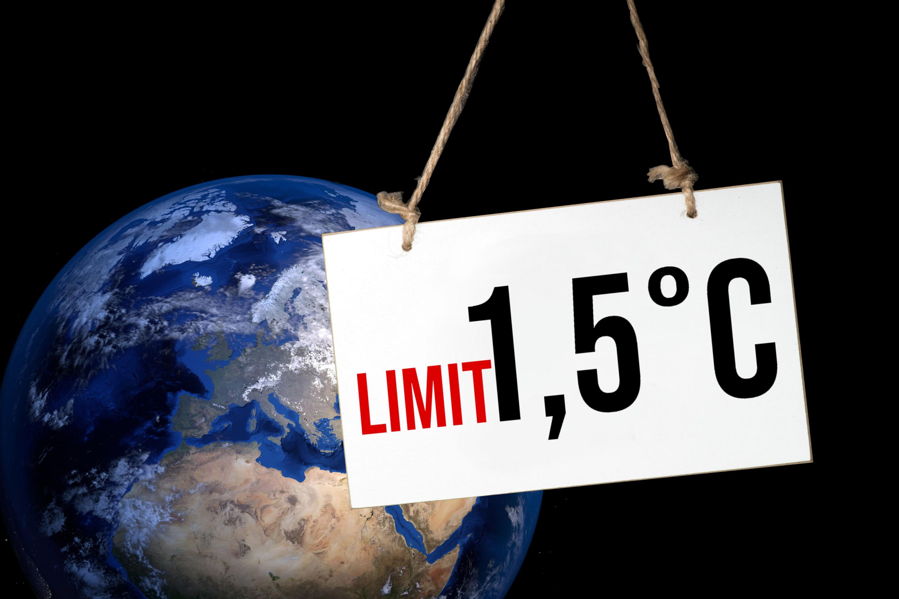 In einer Grafik sind die Weltkugel und ein Schild mit dem Schriftzug „Limit 1,5 Grad Celsius“ abgebildet.