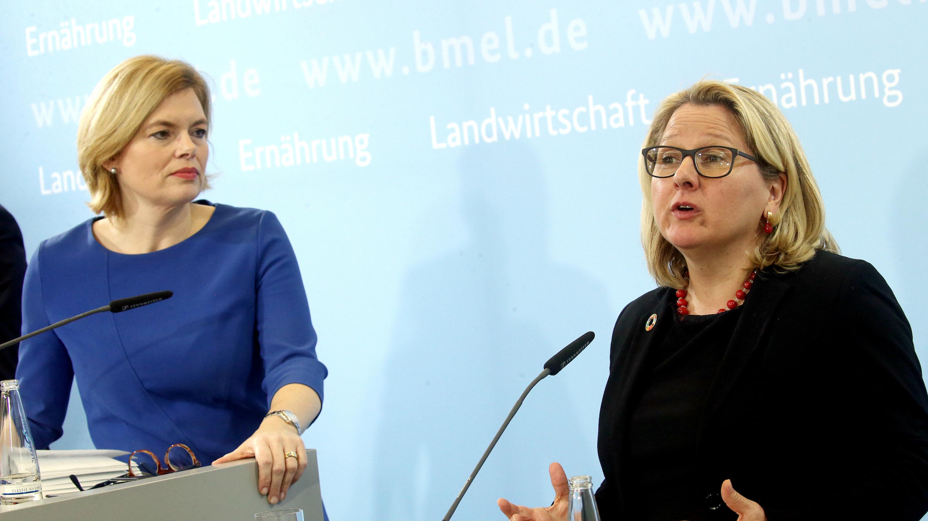 Das Bild zeigt die beiden Ministerinnen vor einer hellblauen Stellwand an Mikrofonen. Klöckner schaut Schulze beim Reden zu, Schulze gestikuliert.