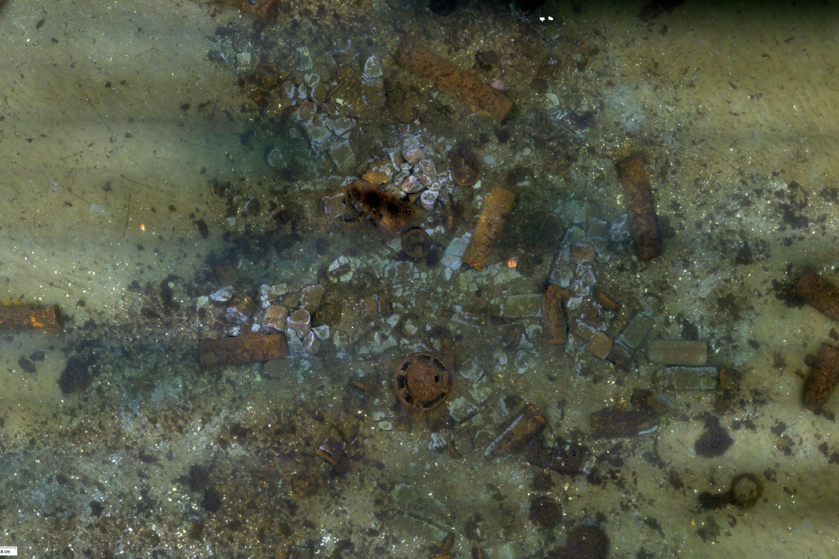 verschiedene rostige Objekte sind am Meeresboden verstreut