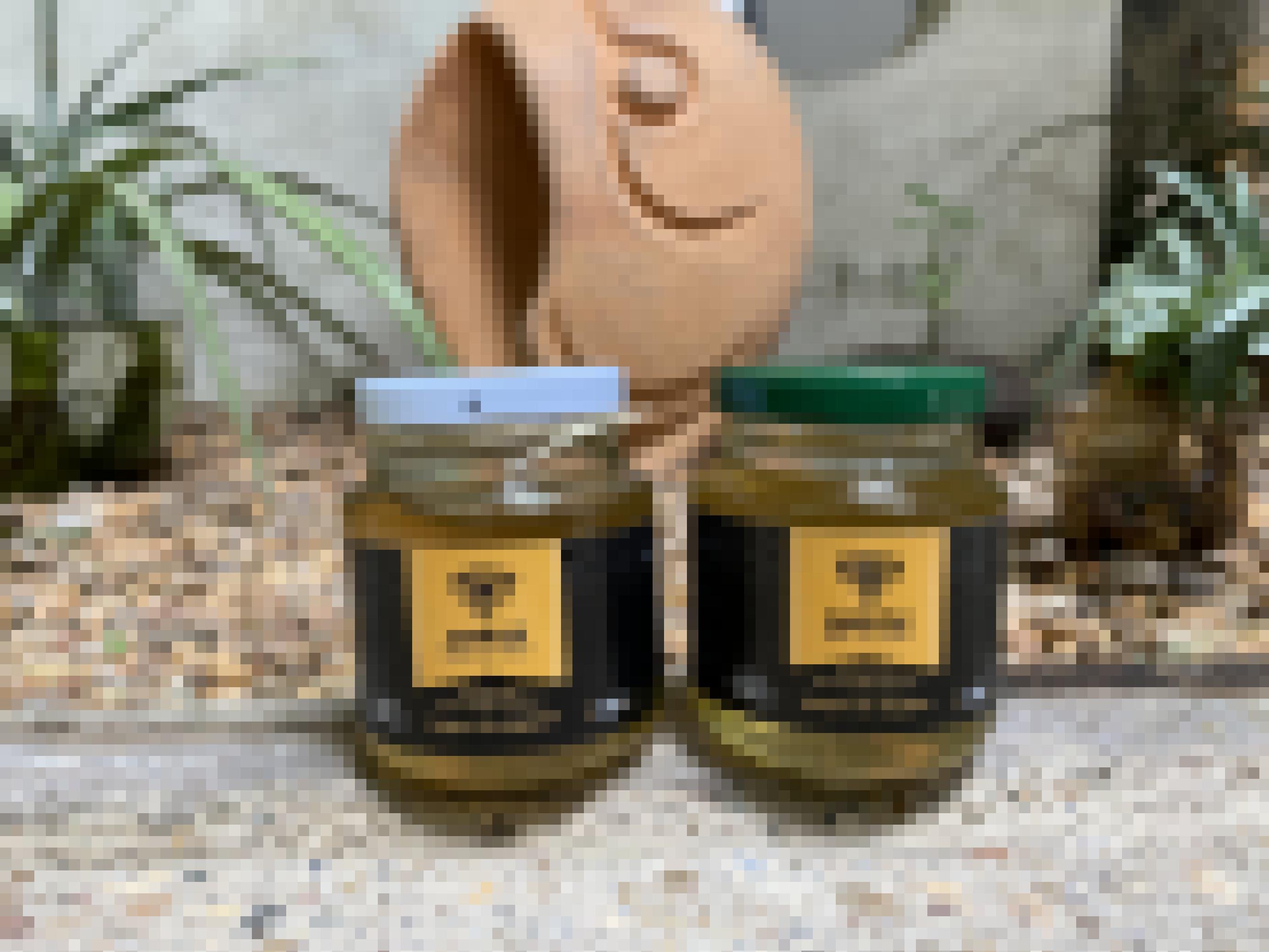 Zwei kleine Gläser mit goldenem Honig gefüllt.