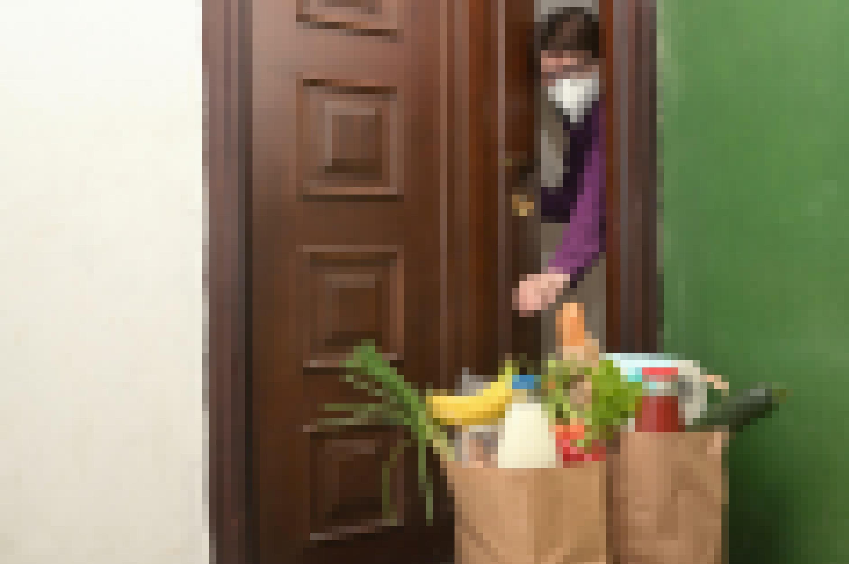 Eine Frau in Quarantäne betrachtet die für sie abgestellten Einkäufe vor der Haustür.