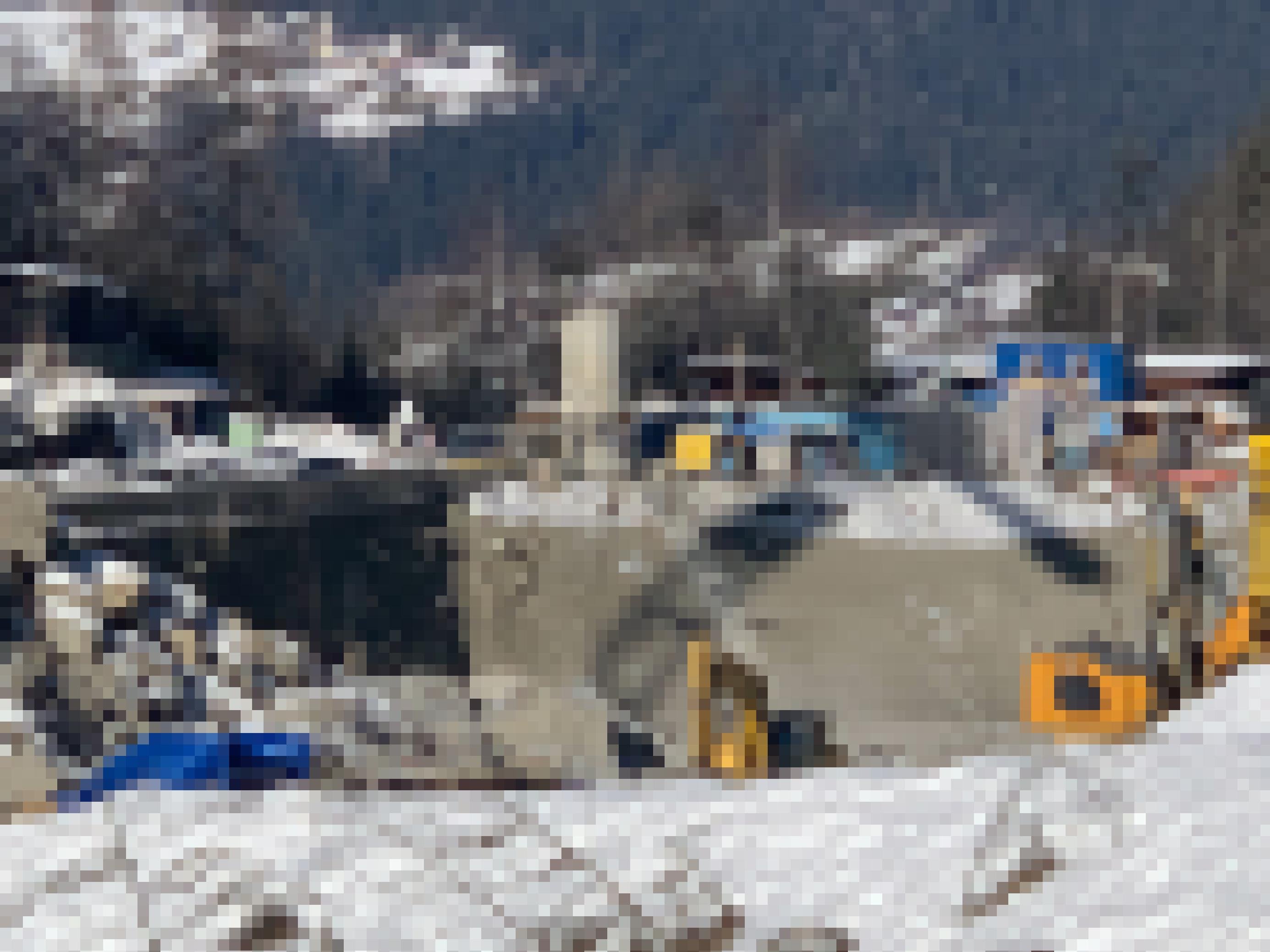 Baustelle an Gebirgsbach mit Betonwand und Baustellengerätschaften