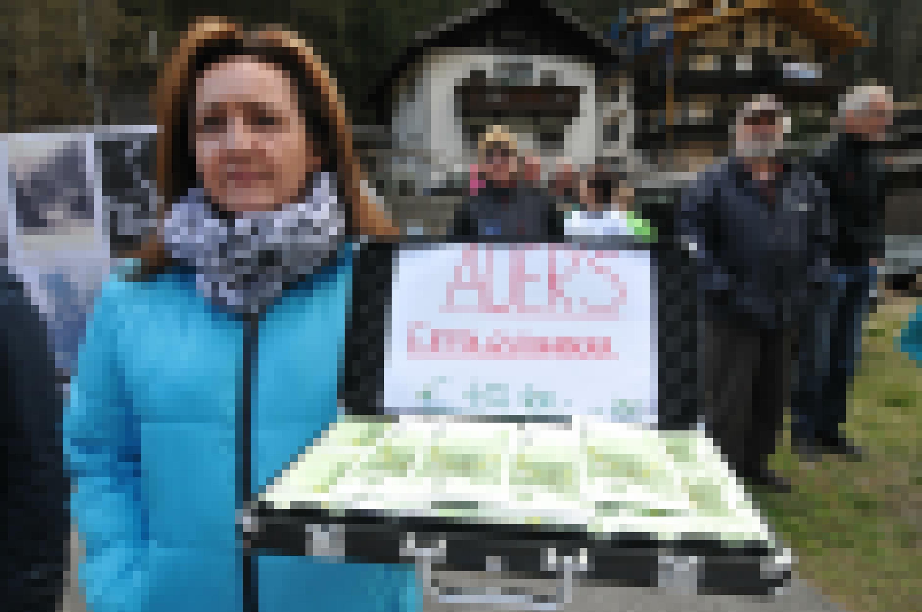 Frau mit Aktenkoffer mit Papiergel. Auf einem Zettel steht: Auers Erfolgshonorar € 456.400 + USt.